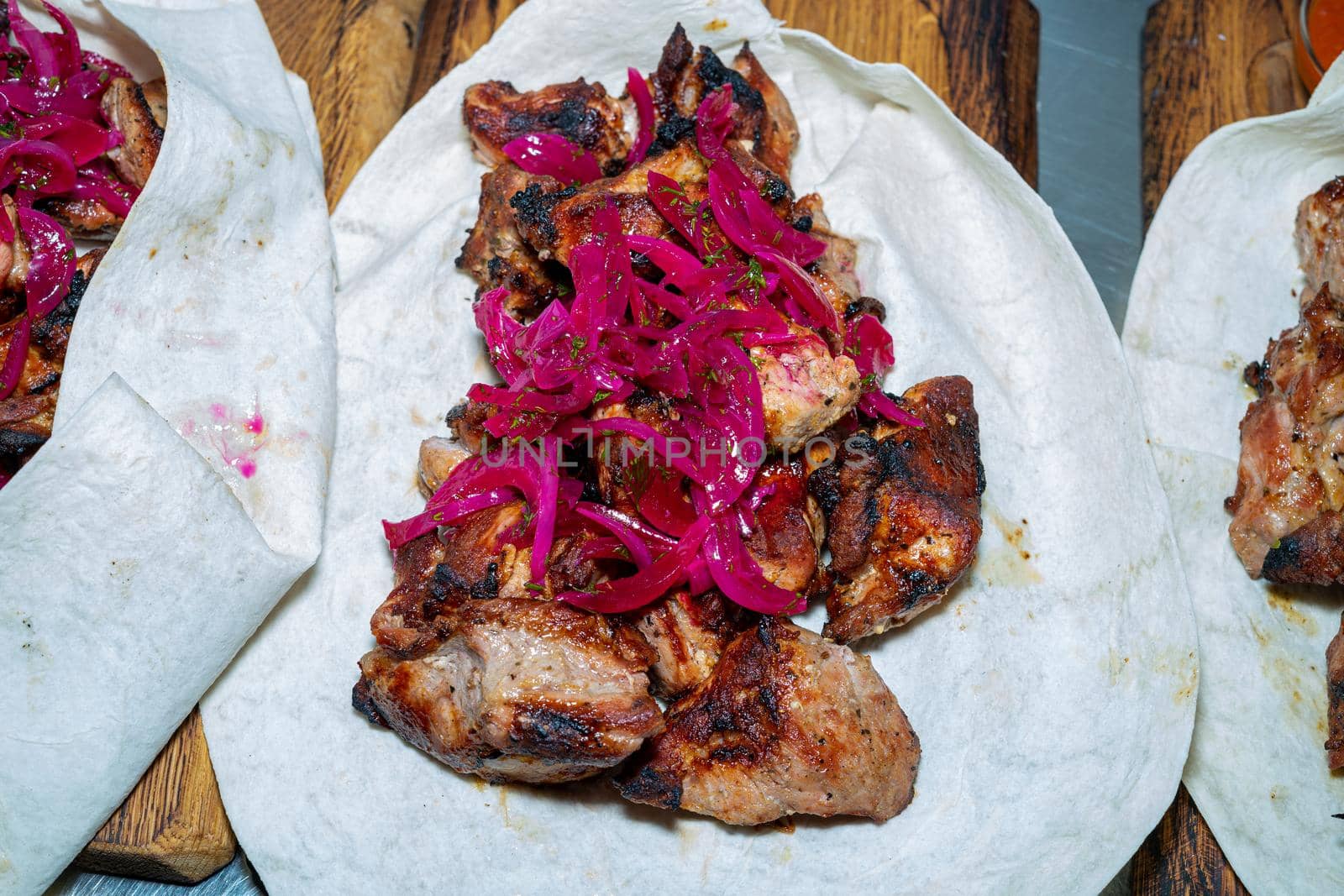 Shish kebab in pita is ready to eat. Lavash with barbecue on a wooden board.