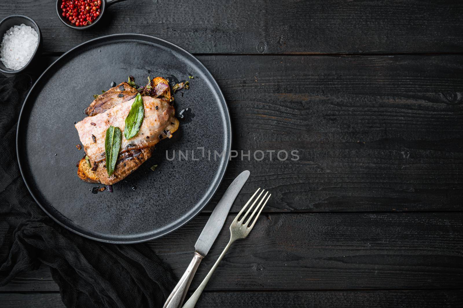 Liver bacon and onions on bread cooked meal on plate on black surface, top view with copy space.