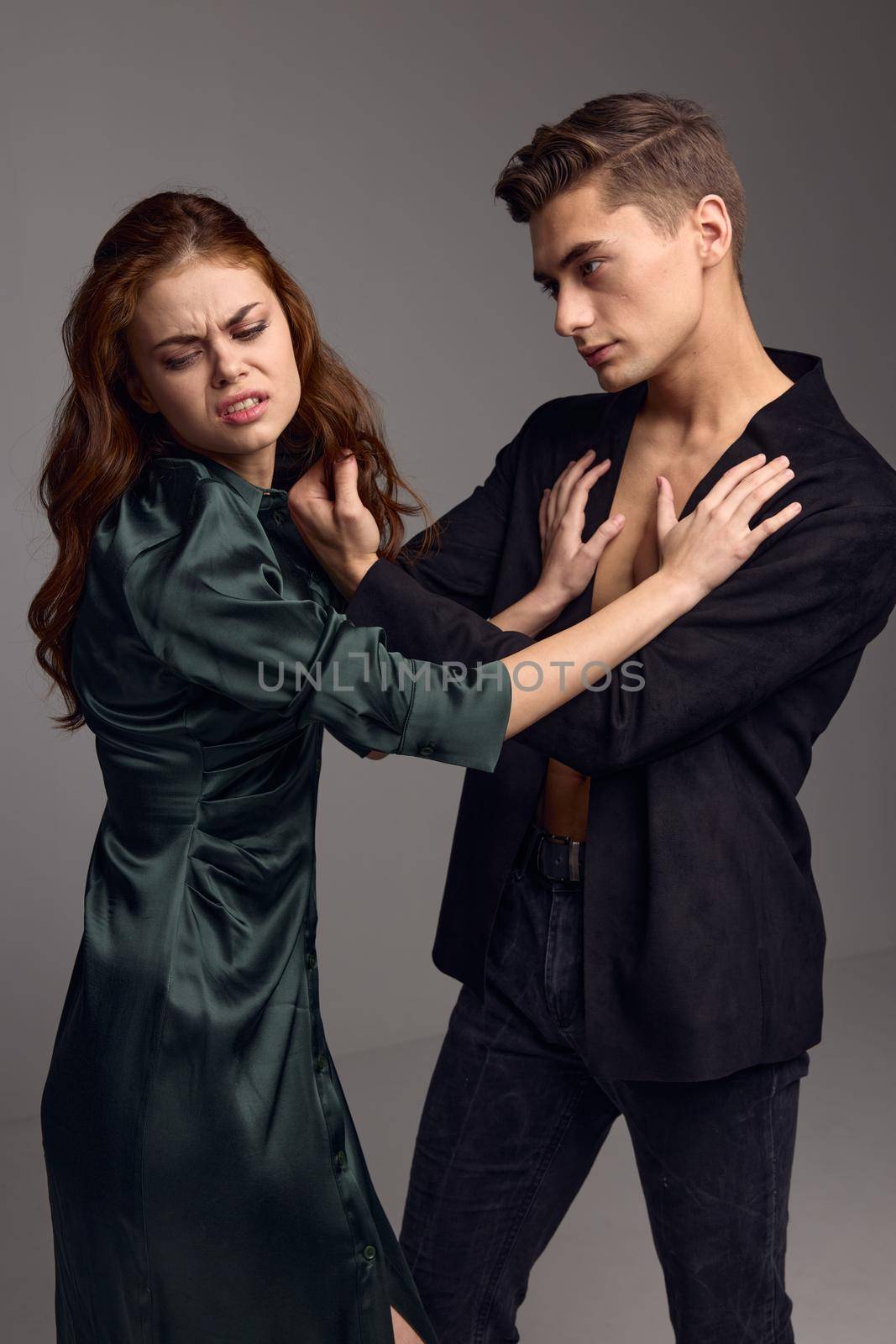 aggressive man and woman fighting on gray background conflict domestic violence. High quality photo