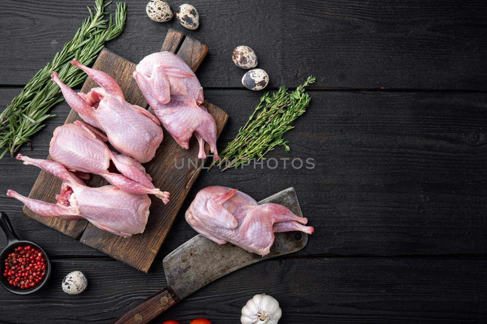 Fresh raw meat quail ready for cooking, flat lay, on black wooden background with space for text