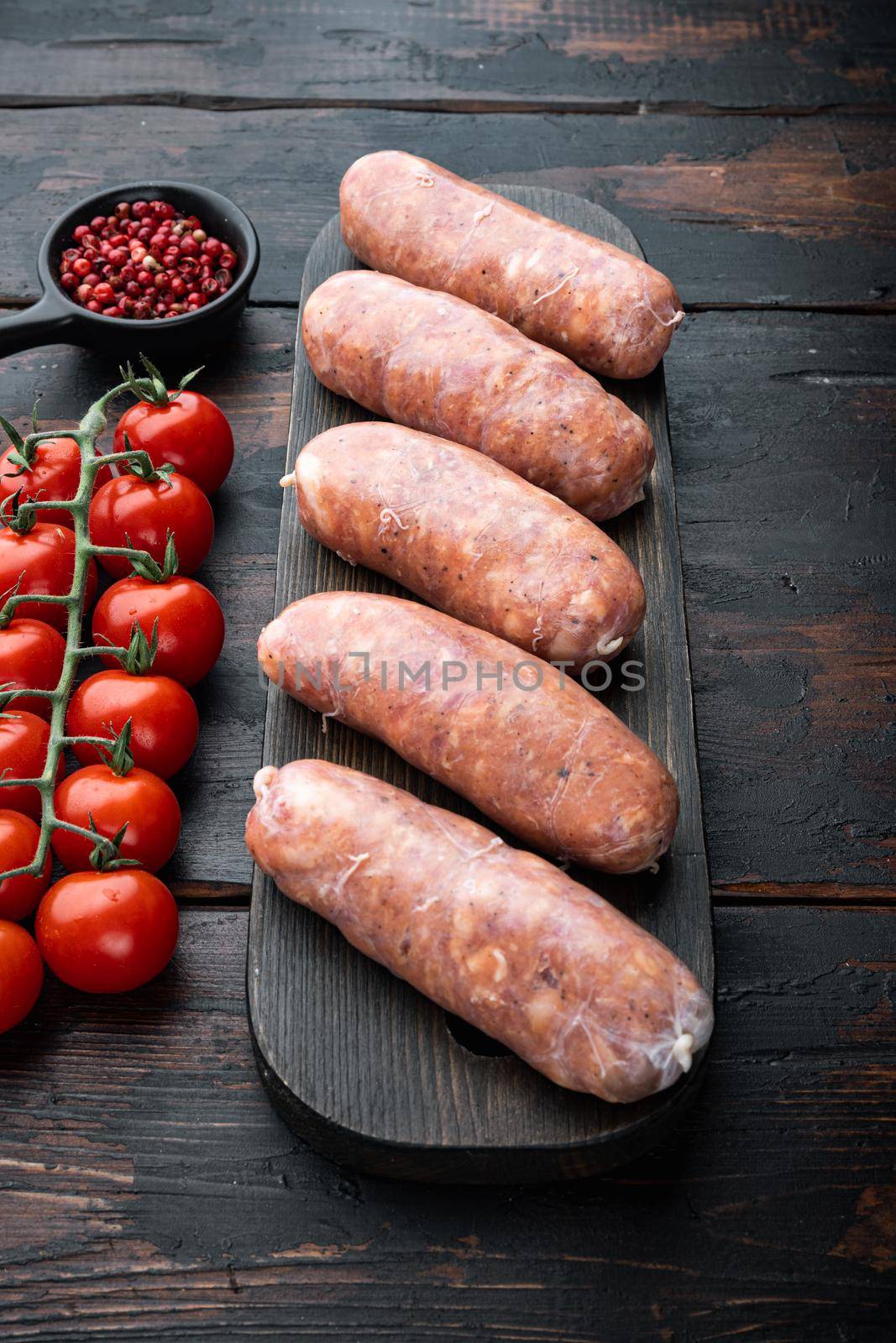 Raw pork sausages, on old dark wooden background by Ilianesolenyi