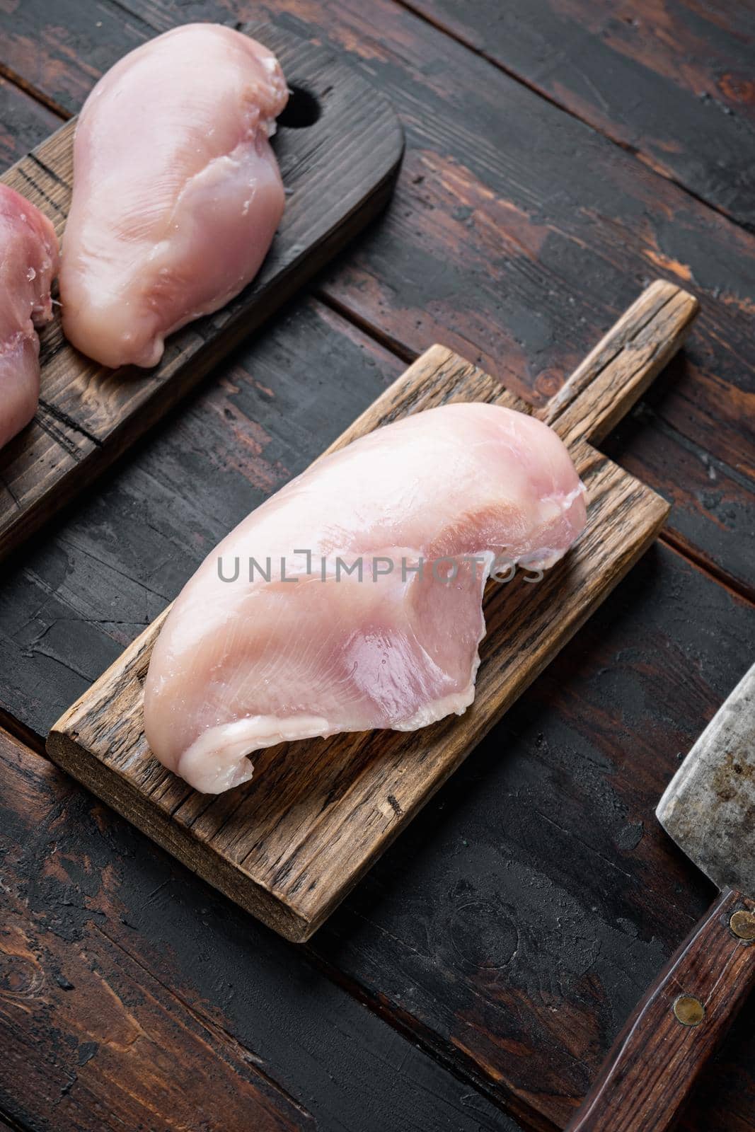 Chicken uncooked meat with butcher knife, on dark wooden background