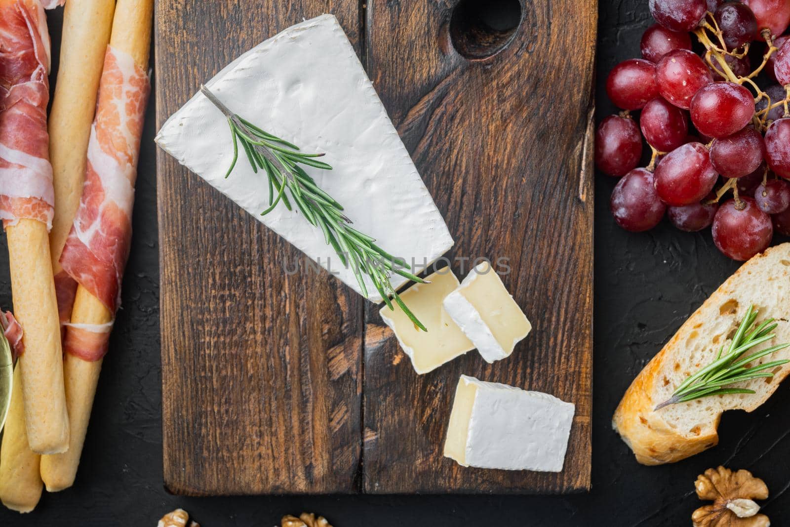 Brie type of cheese set, on black background, flat lay