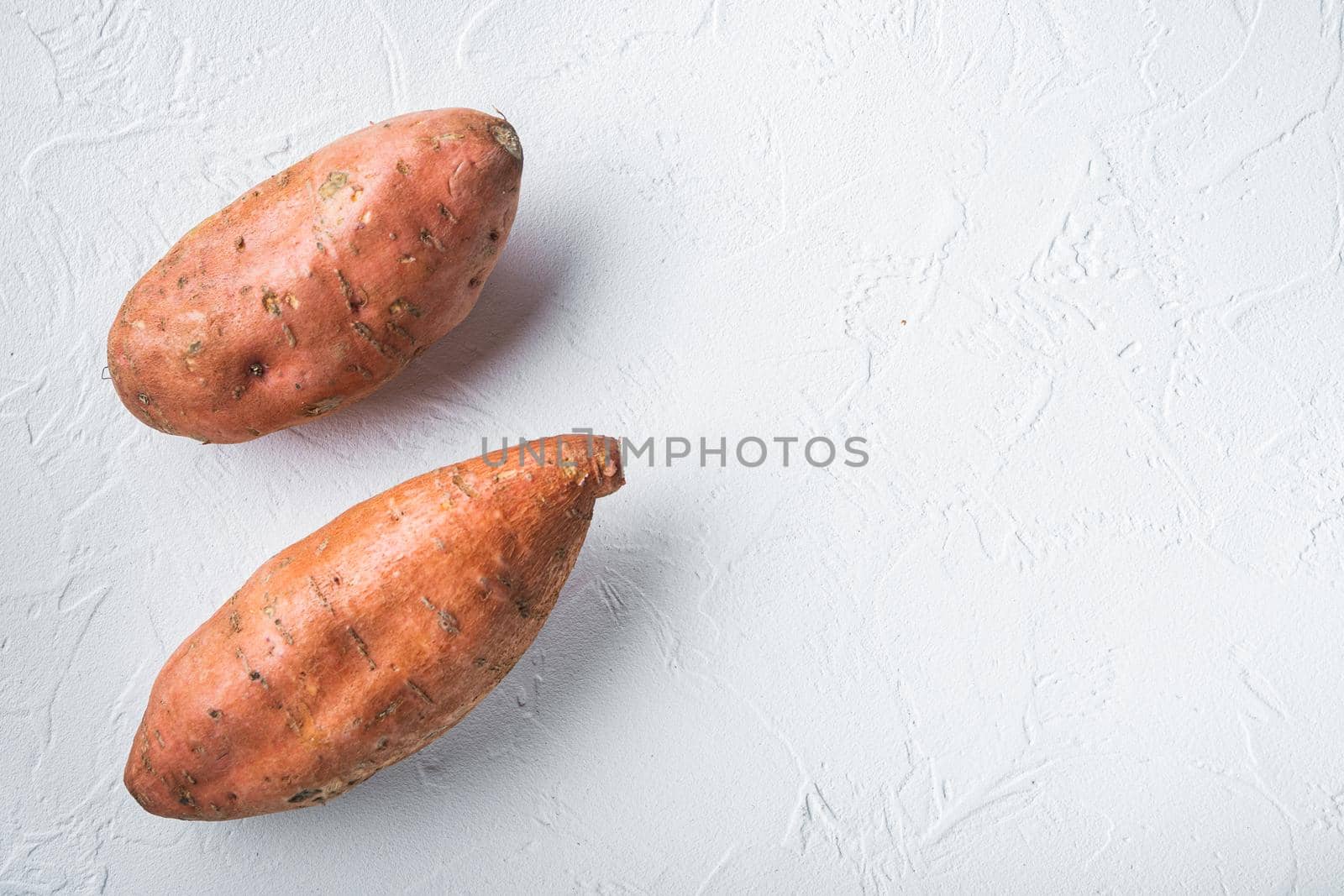 Raw whole sweet potatoe on white background, flat lay with copyspace.