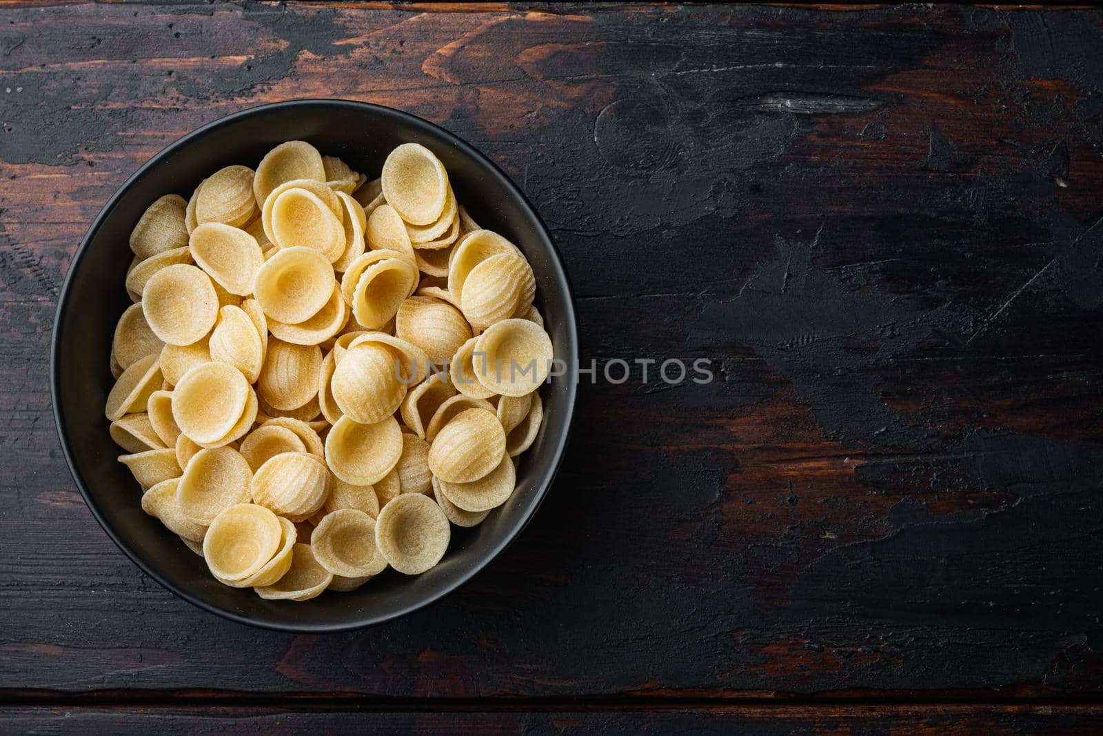 Durum wheat semolina pasta, on old wooden table, top view with copy space for text