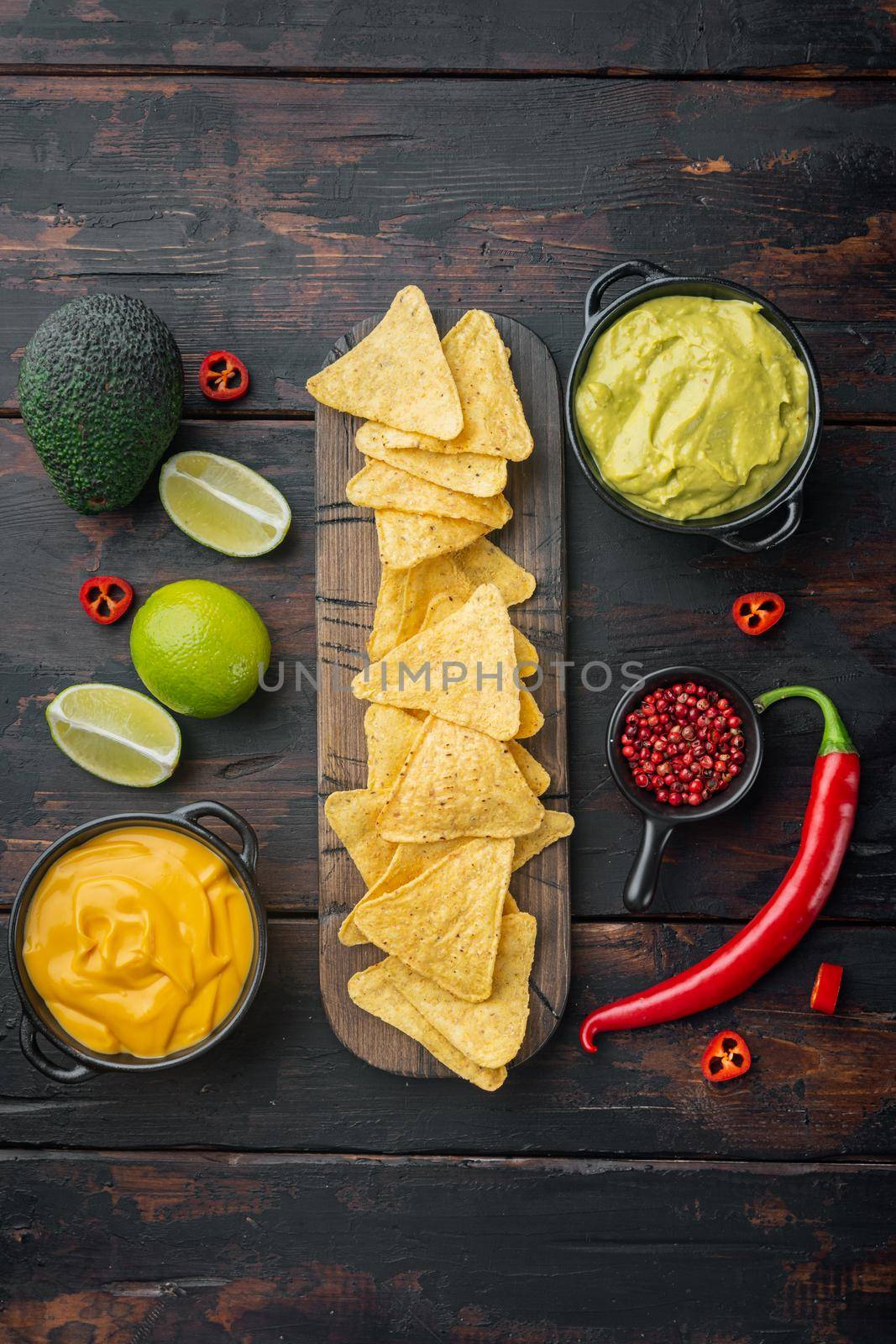 Nachos corn chips with traditional dip sauce , on old wooden table, top view or flat lay by Ilianesolenyi