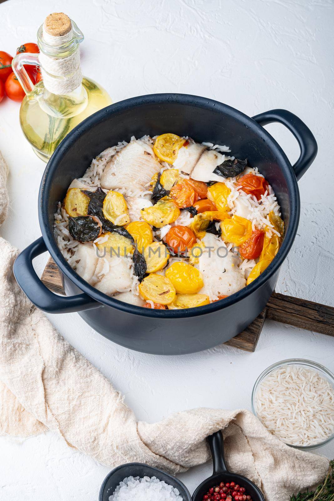 White tilapia fish with basmati rice and cherry tomatoes , on white background by Ilianesolenyi