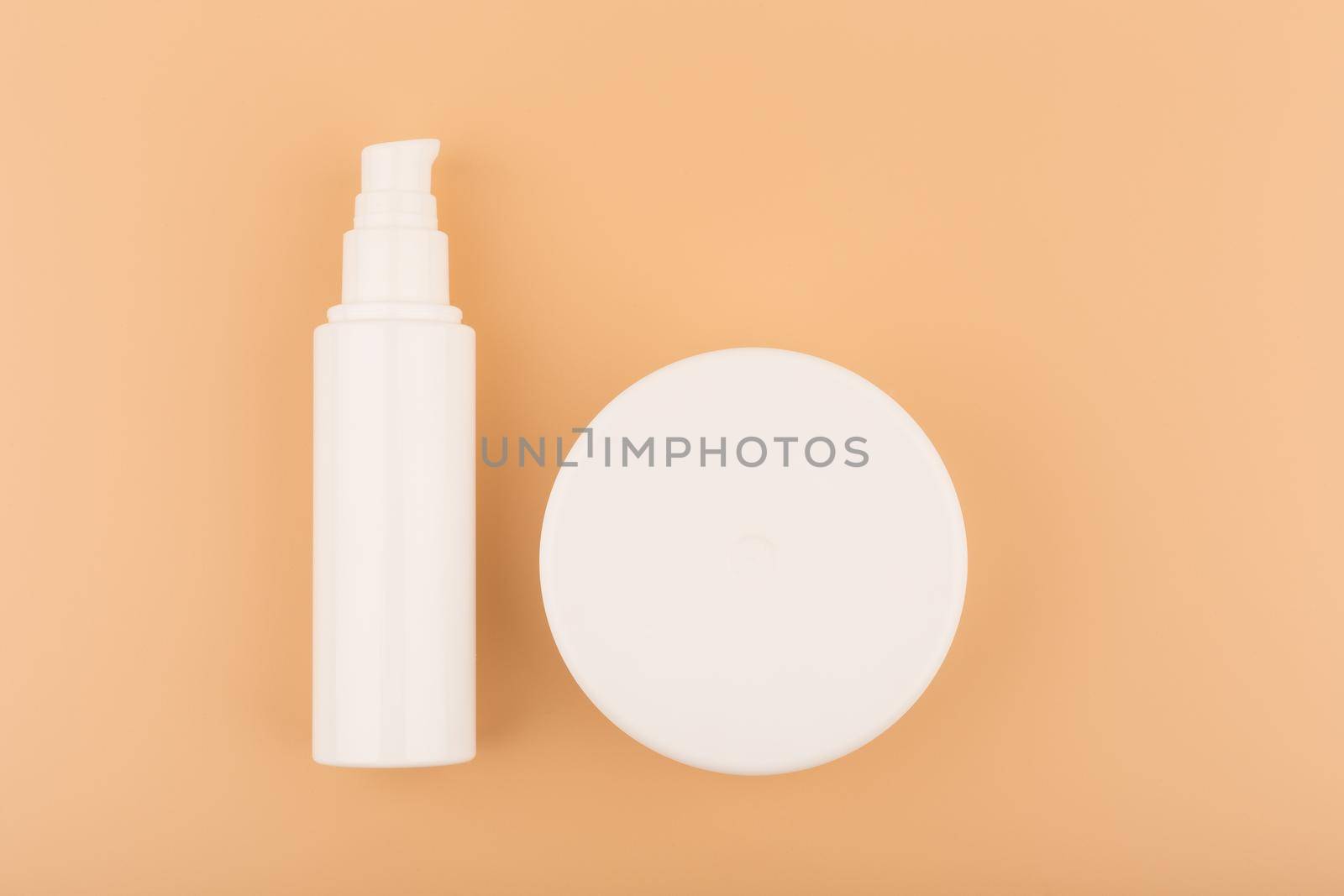 Flat lay with white unbranded face and body cream on beige decorated background. High quality photo