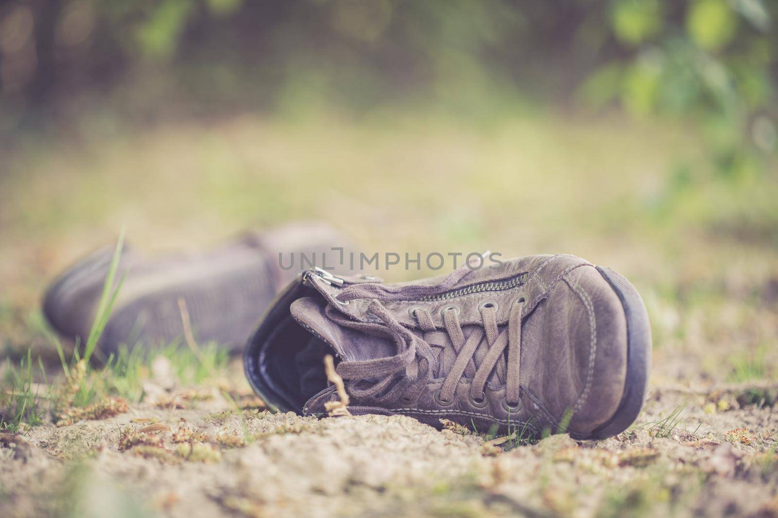 Dusty old shoe abandoned in the nature. Concept for missing.
