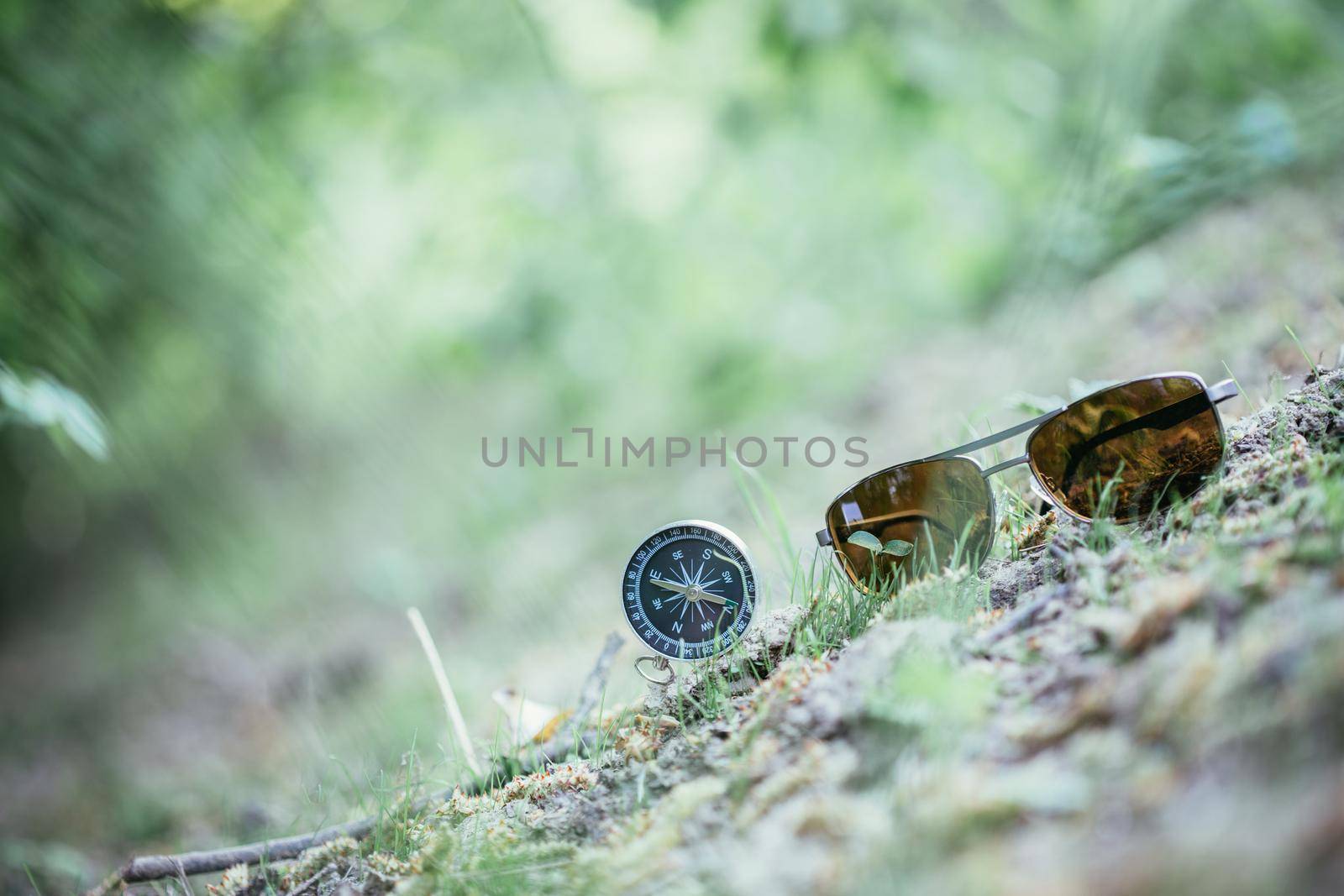 Vintage compass and sunglasses lying on the floor. Adventure and discovery concept.