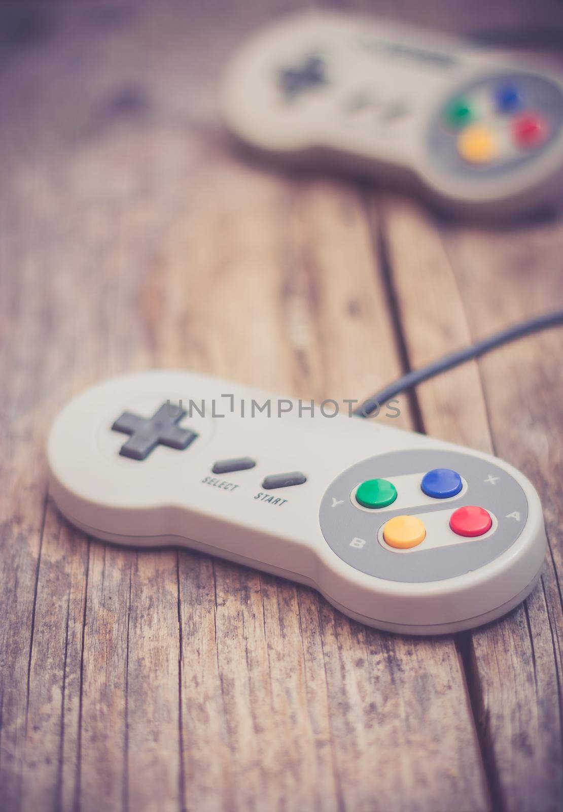 Playing retro video games: Controller on rustic wooden background by Daxenbichler