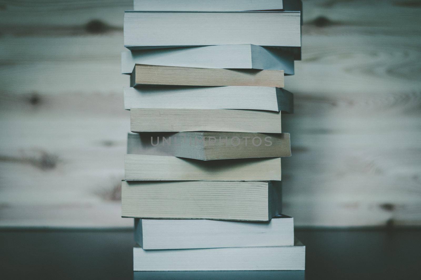 Knowledge and science concept: Stack of books, wooden background by Daxenbichler