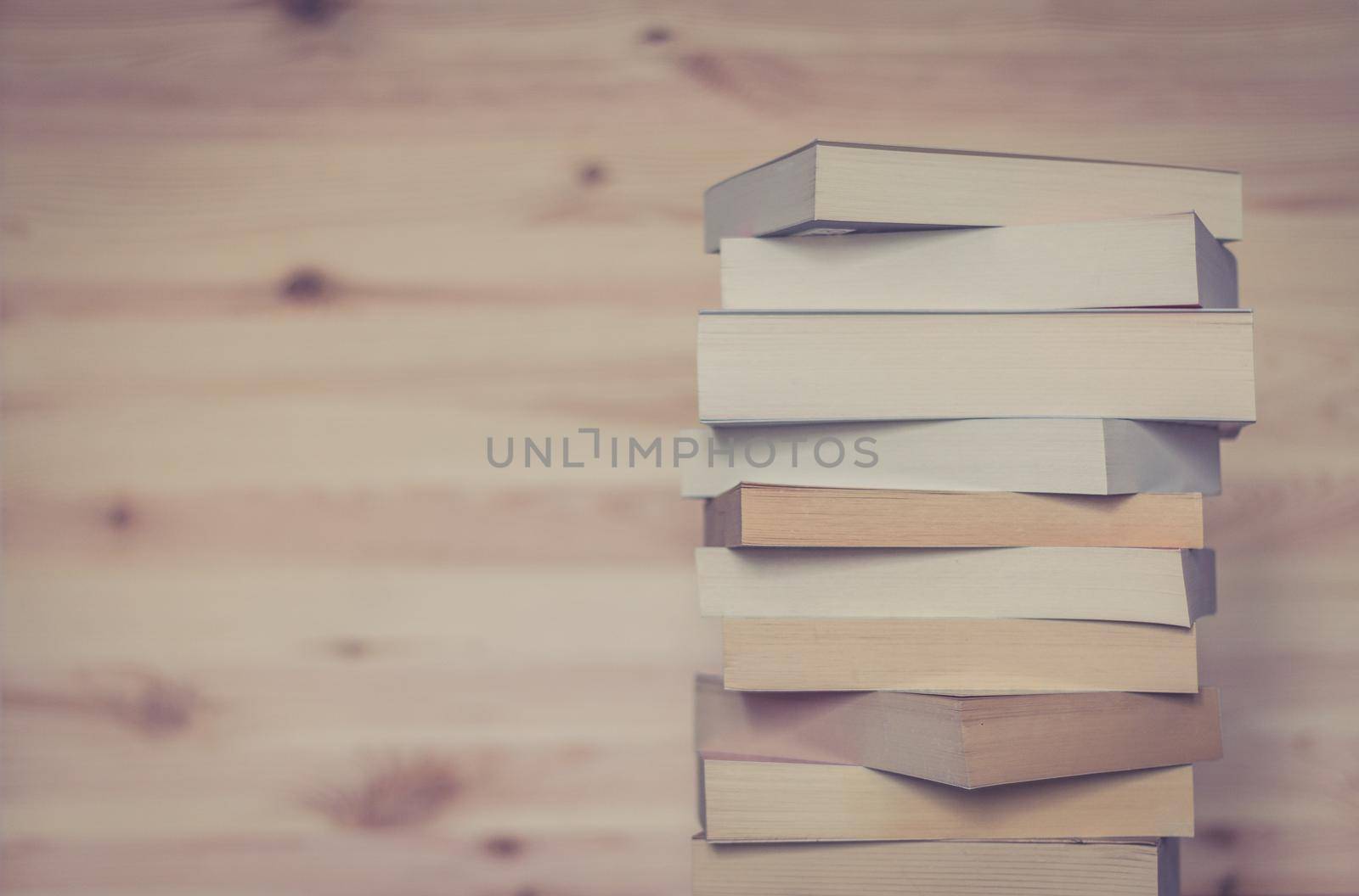 Knowledge and science concept: Stack of books, wooden background by Daxenbichler