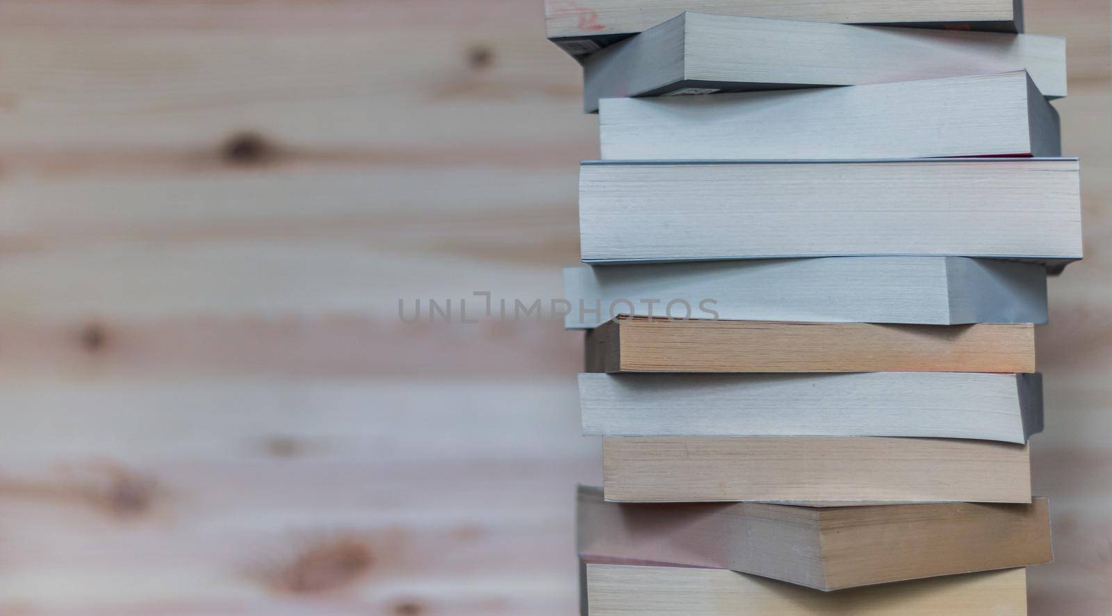 Knowledge and science concept: Stack of books, wooden background by Daxenbichler