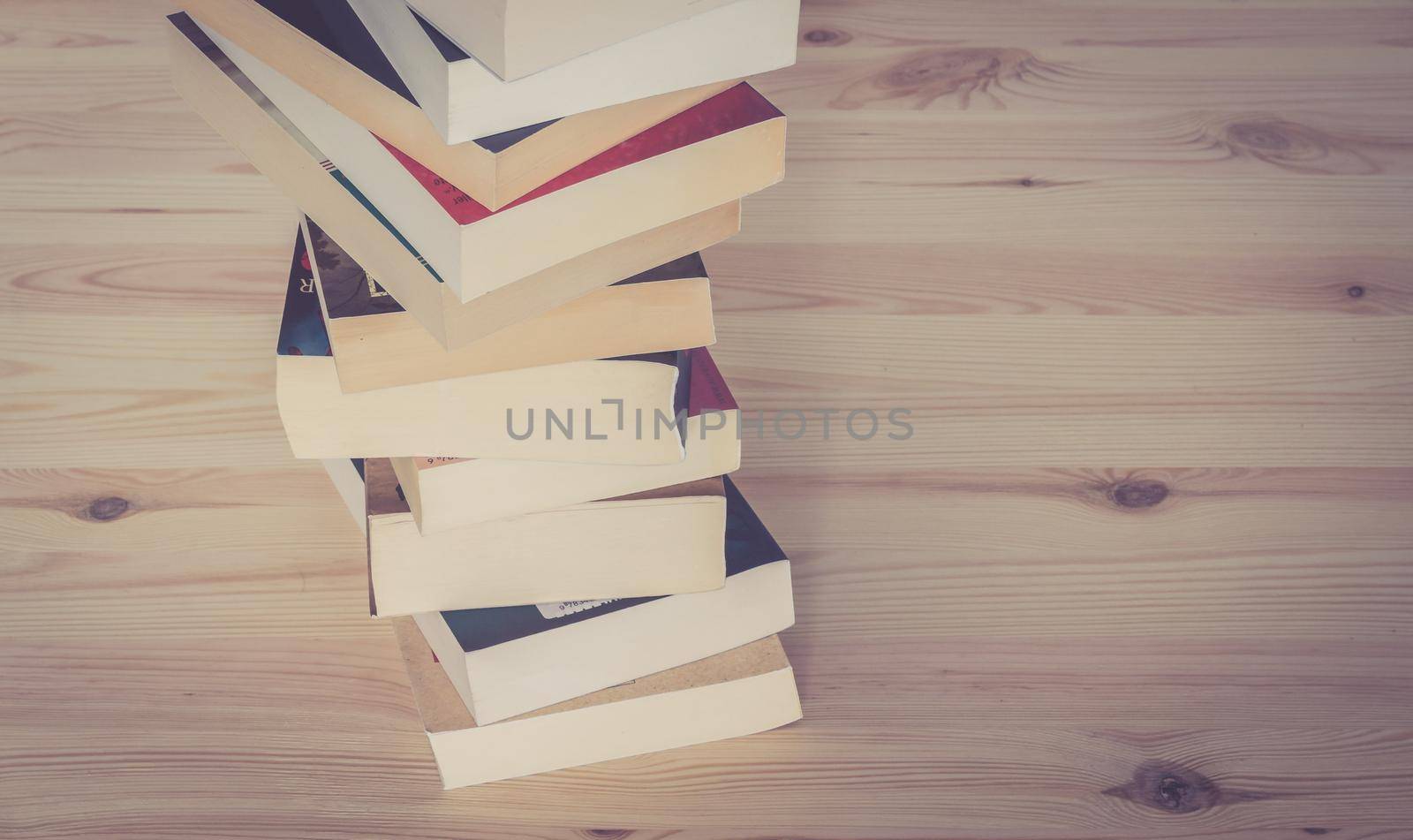 Knowledge and science concept: Stack of books, wooden background by Daxenbichler