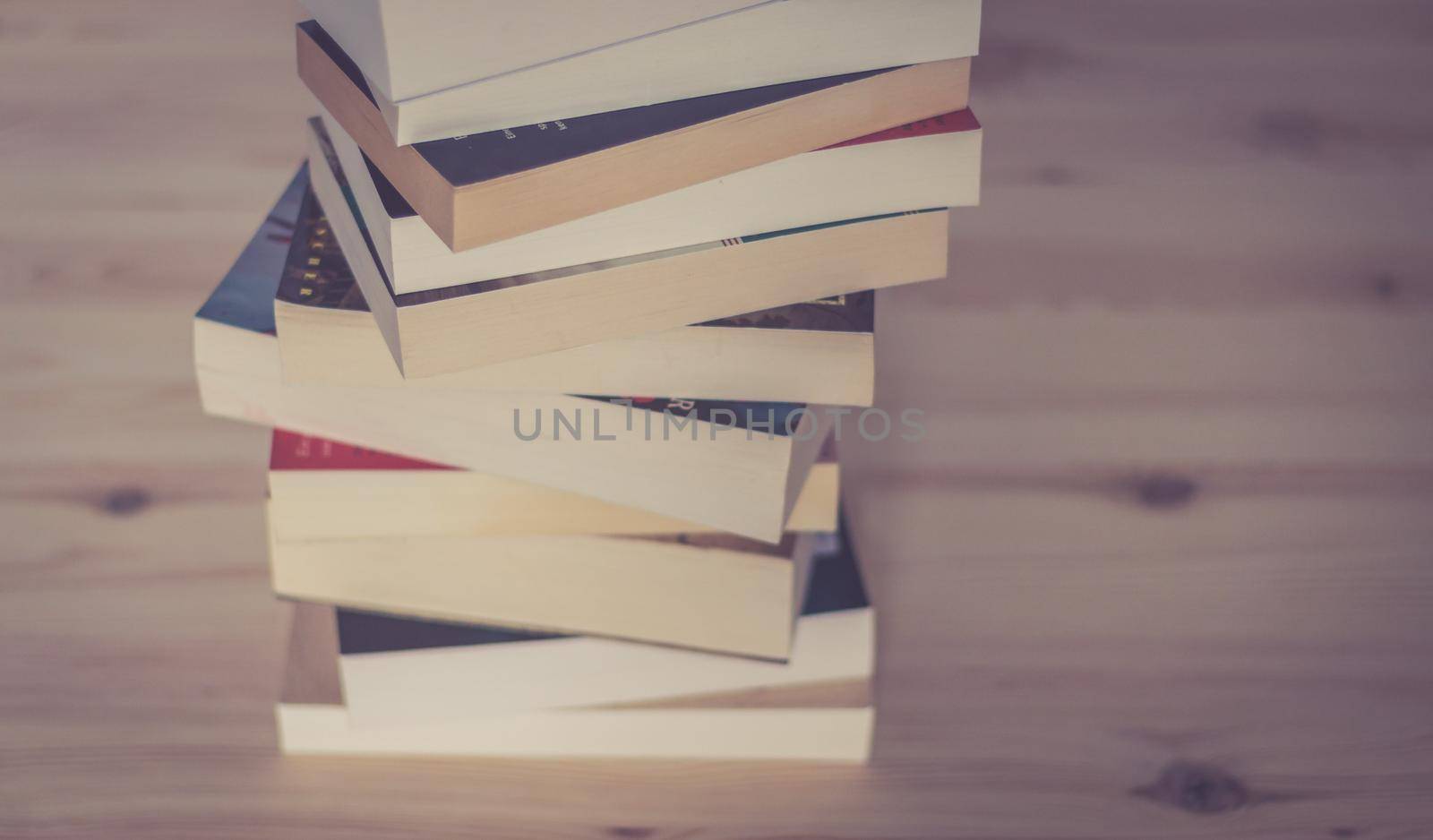 Knowledge and science concept: Stack of books, wooden background by Daxenbichler