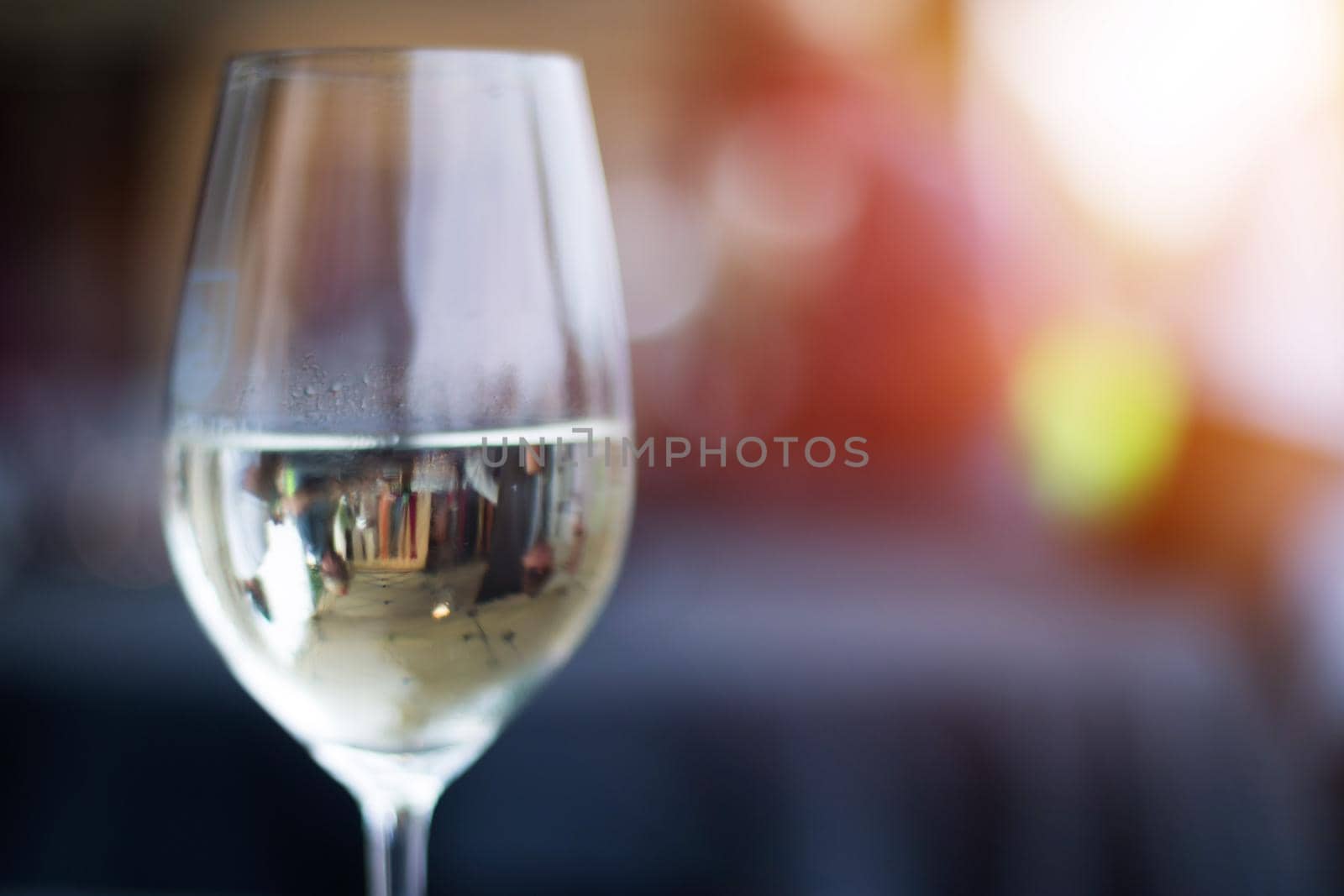 Enjoying a glass of white in the evening. Glass holding in hand, outdoors by Daxenbichler