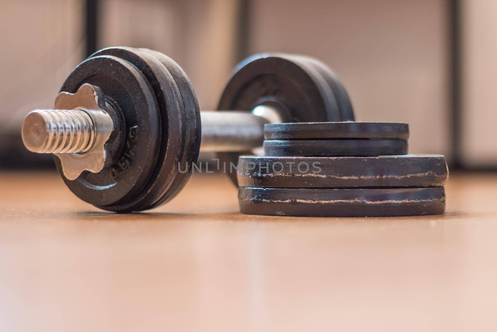 Black bar bell on the wooden floor, physical exercise