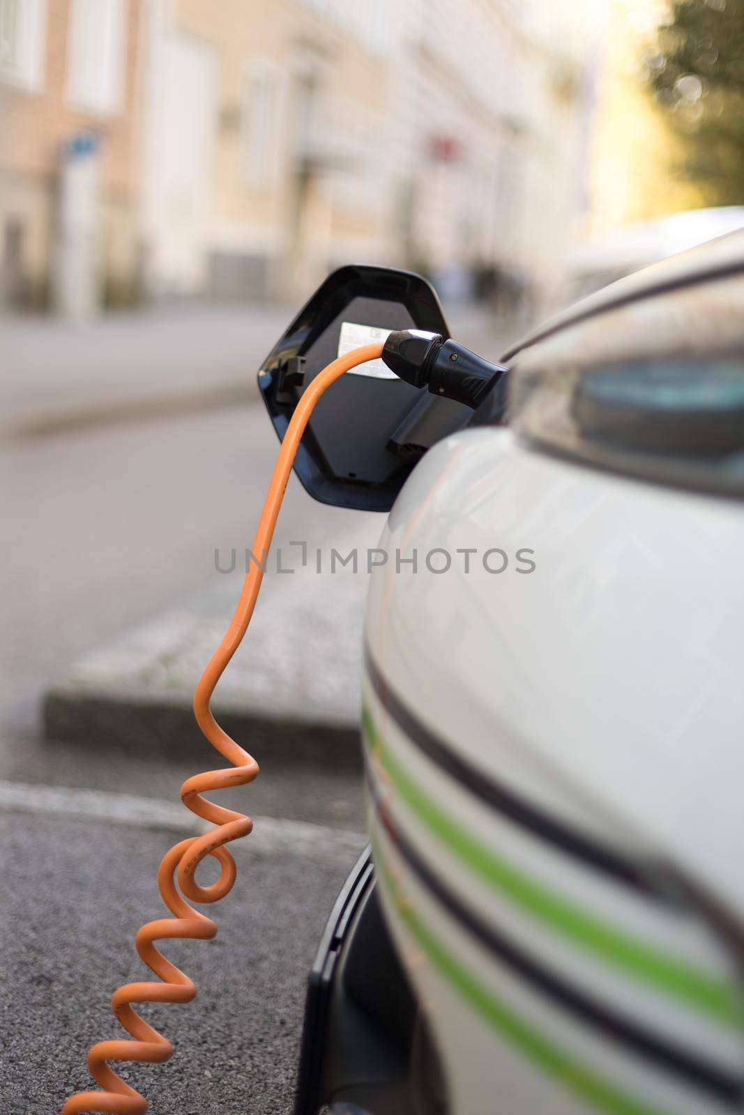 Charching an electric car with power cable supply, plugged in by Daxenbichler