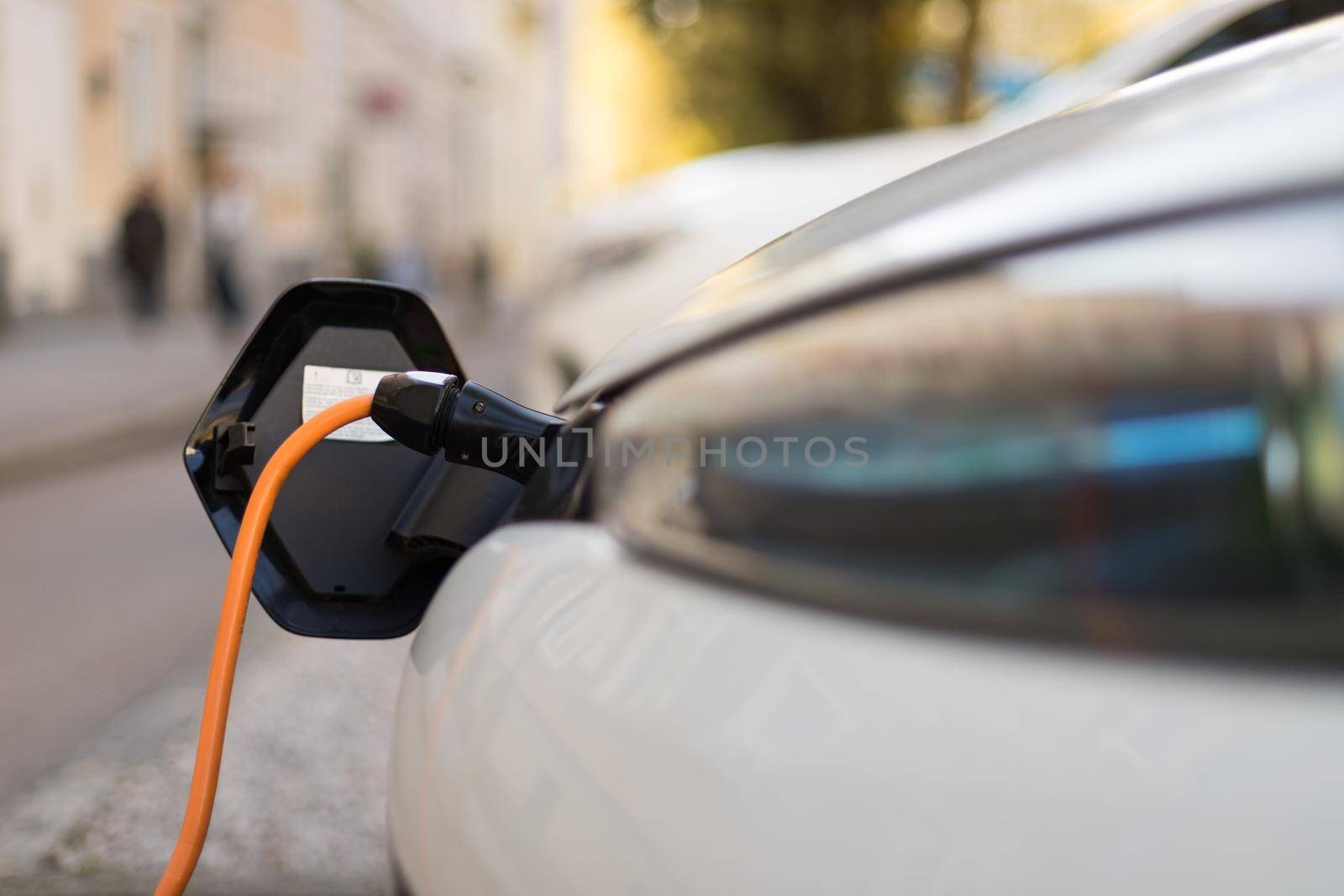 Electric car recharging with charge cable and plug leading to charge point.