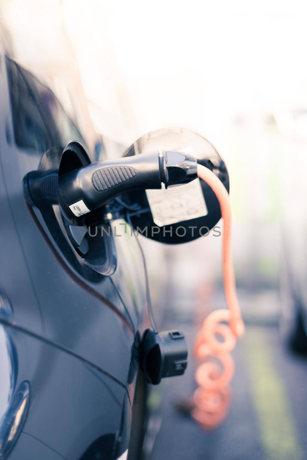 Electric car recharging with charge cable and plug leading to charge point.