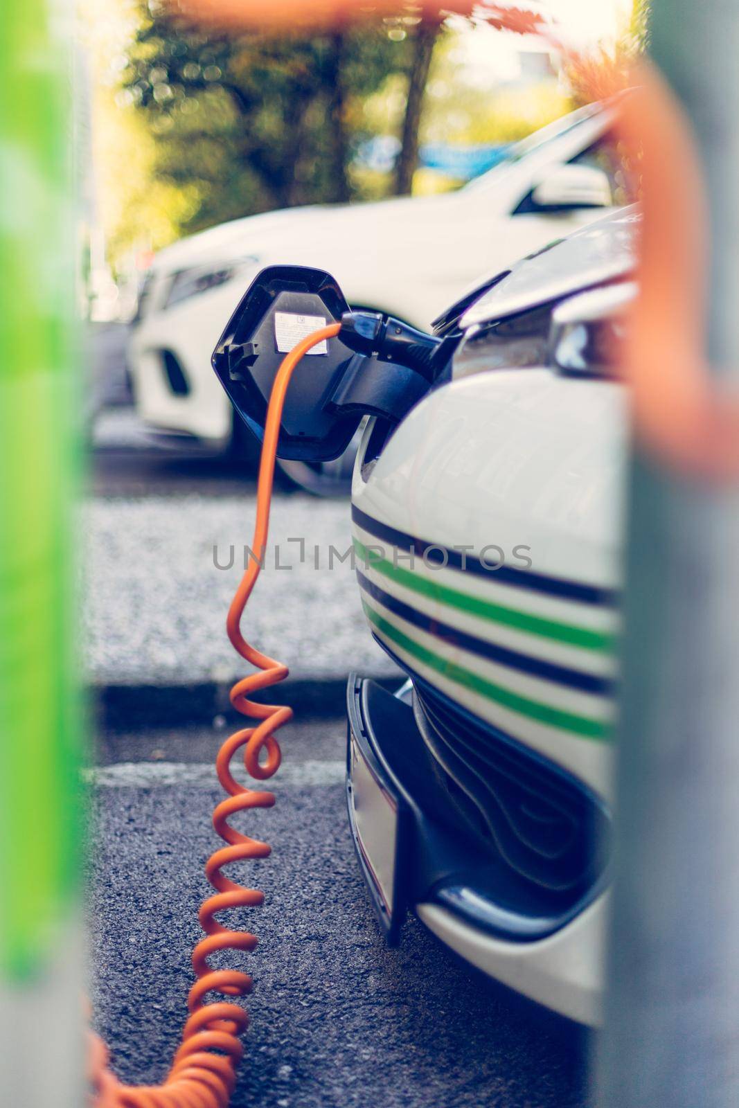 Electric car recharging with charge cable and plug leading to charge point.