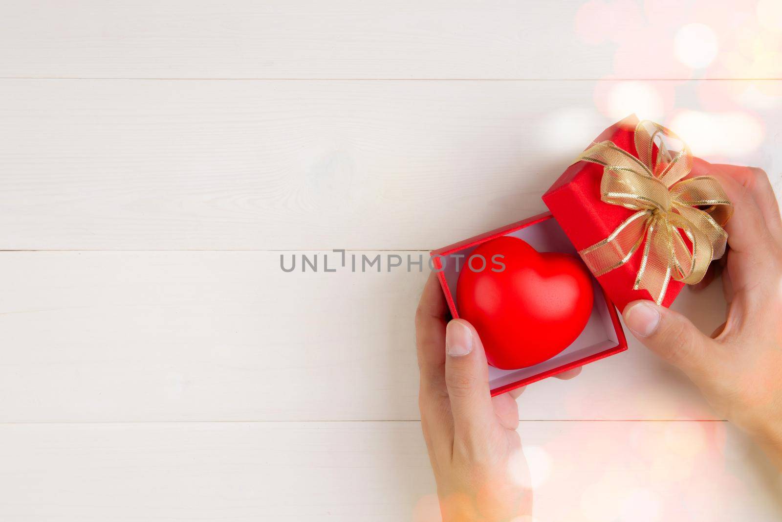 Valentine day, hand open red gift box with heart shape on wooden white background, celebration and anniversary with giving love, presents with romantic and surprise, holiday and festive concept.