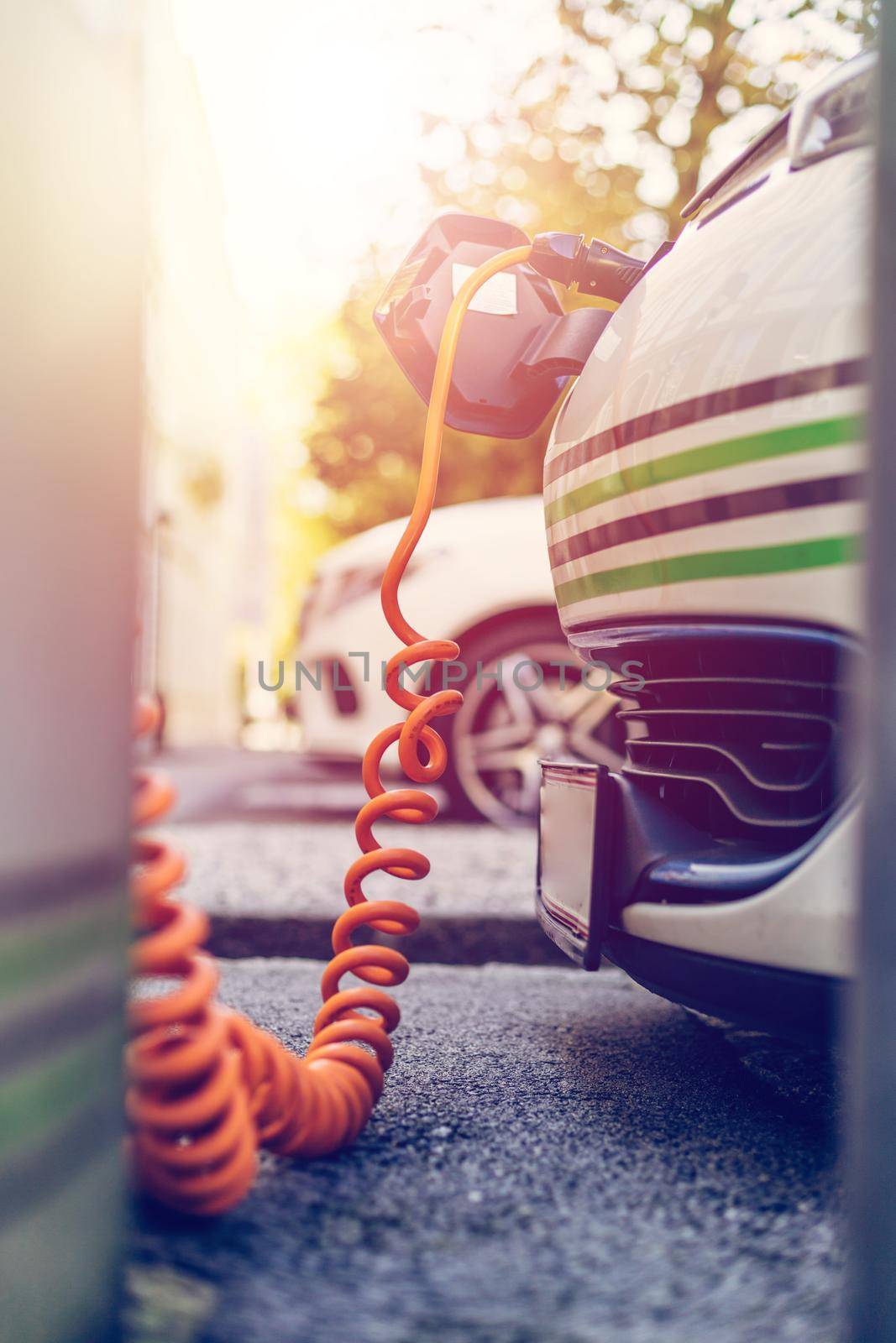 Electric car recharging with charge cable and plug leading to charge point.