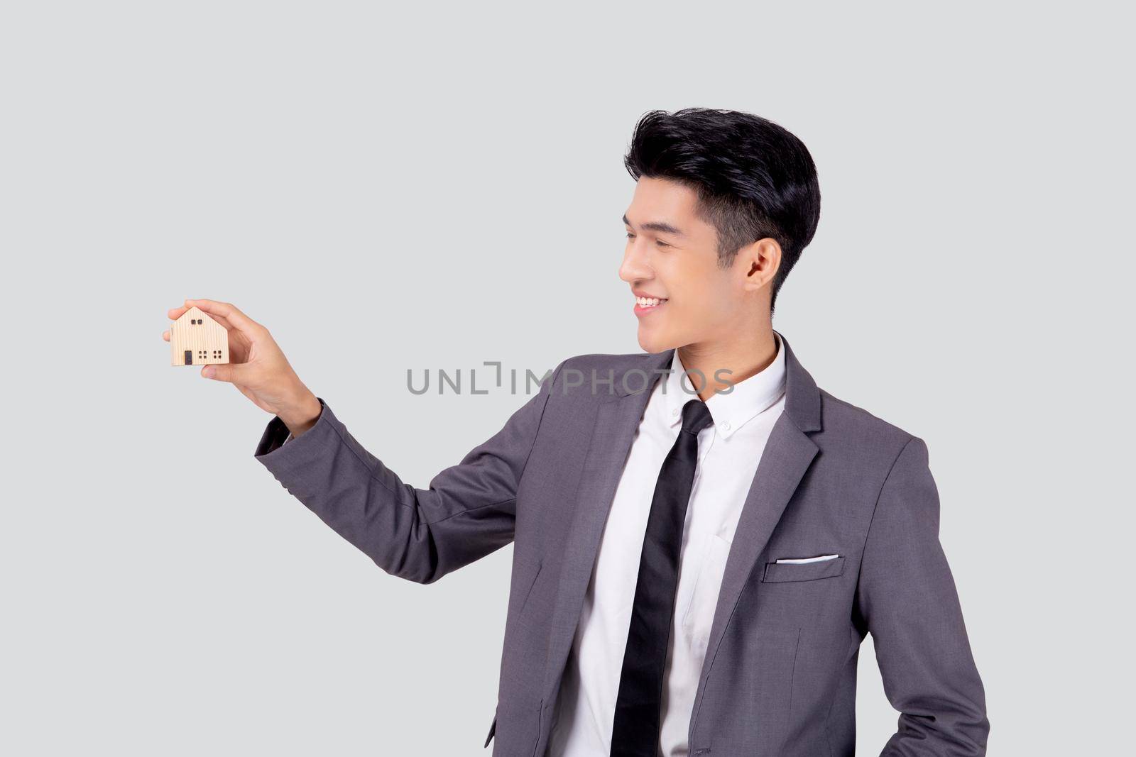 Young asian business man holding the home symbol of saving for future, insurance agent and credit, ownership house, debt and loan of finance, purchase home and refinance, investment real property.