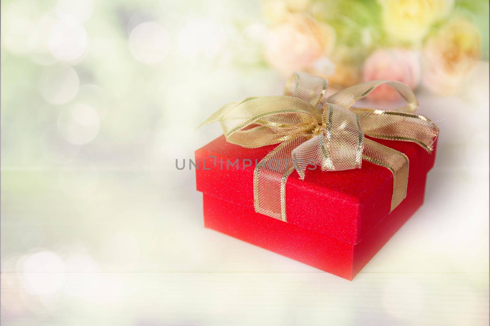 Gift box and flower on on table with blur bokeh background, love and romance, present in celebration and anniversary on table of romance and happy birthday, copy space, nobody, valentine day concept. by nnudoo