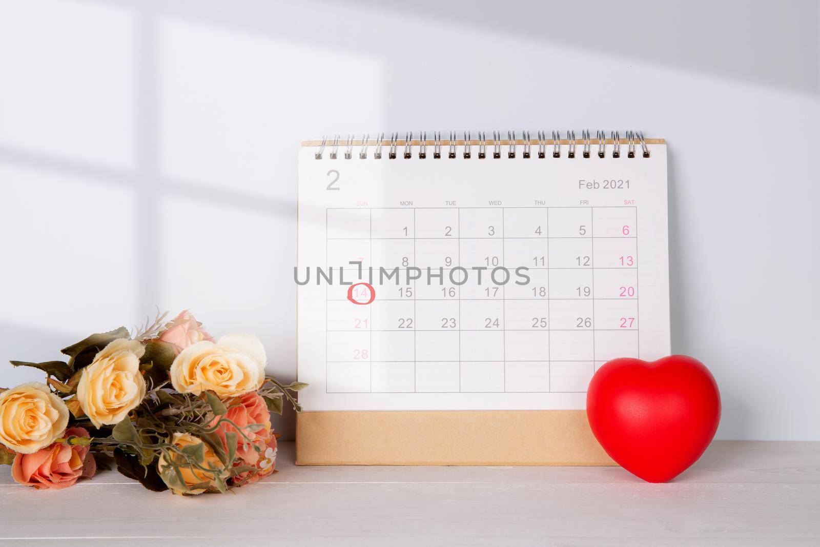 Calendar and flower and heart shape with memo 14 February Valentine day on desk, reminder for surprise of love, romance and sweet, celebration and decoration, top view, holiday concept.