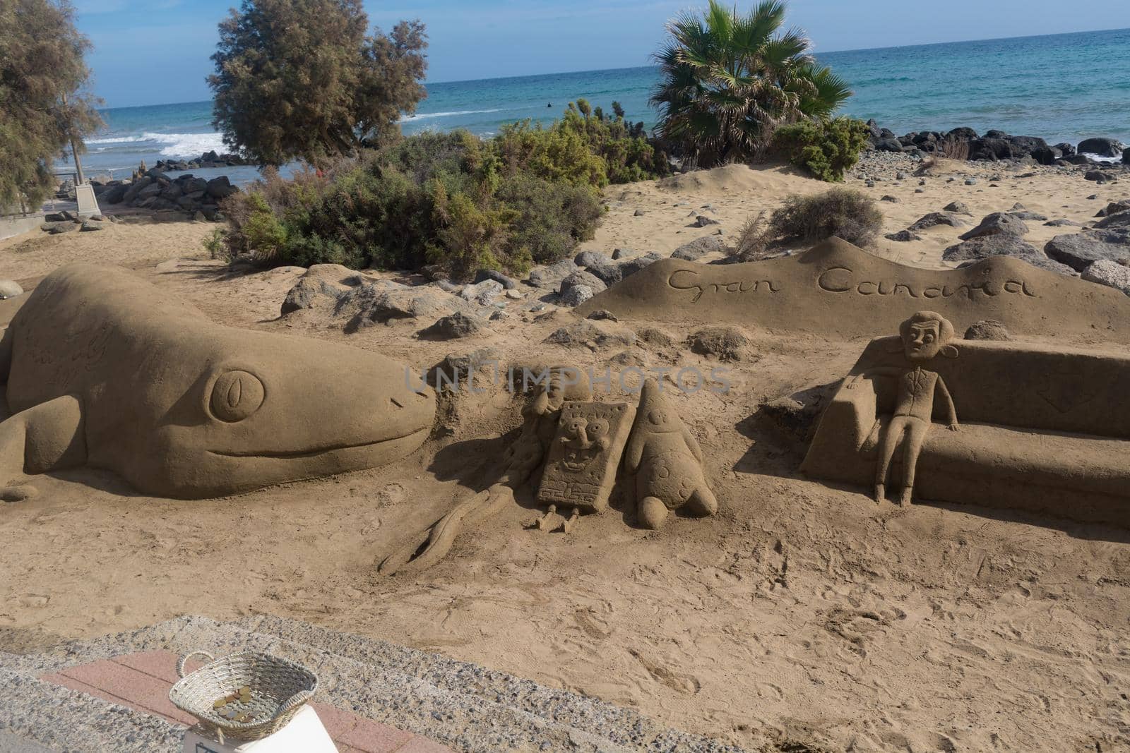 Sand sculptures on the beach of Meloneras, Spain with inscription Gran Canaria