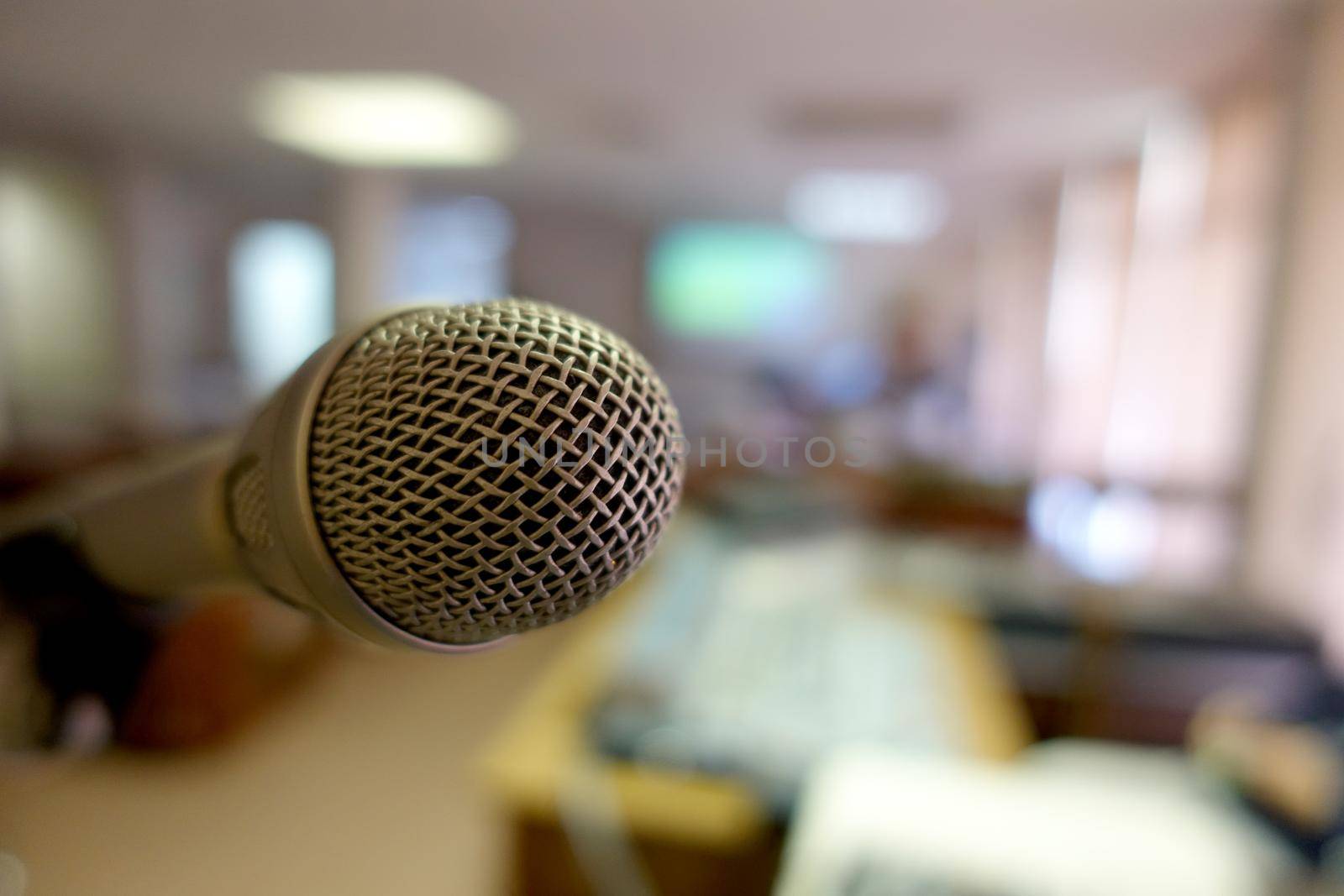 Vintage microphone over the Abstract blurred image of conference hall, study room or seminar room with attendee background, Small Business training concept, Public speaking by NarinNonthamand