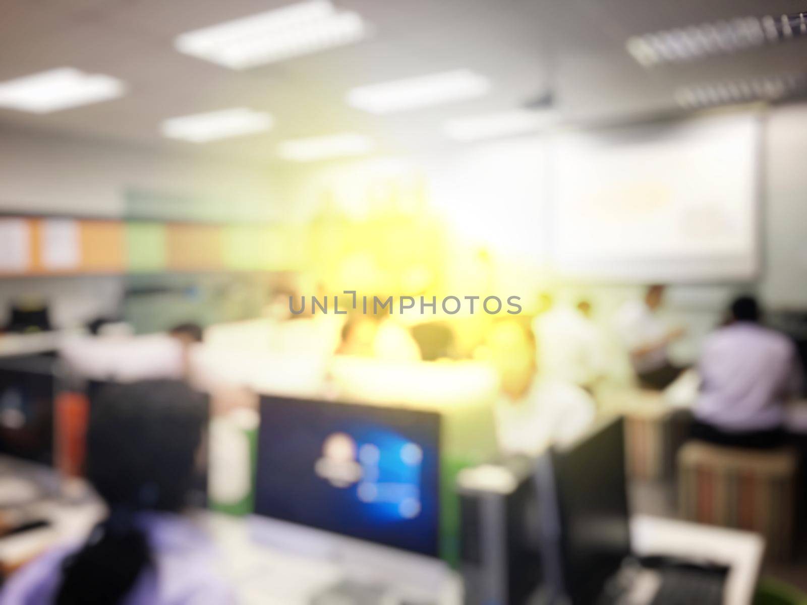 Blurred image of group of students are learning and sitting at desk using computer lap together in classroom for study and workshop in computers room at secondary school. education technology concept. by NarinNonthamand