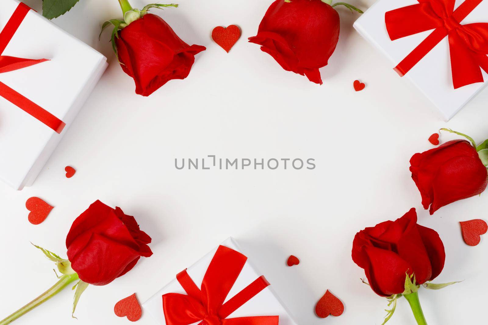 Red rose flowers gifts and red hearts composition on white background top view with copy space. Valentine's day, birthday, wedding, Mother's day concept. Copy space