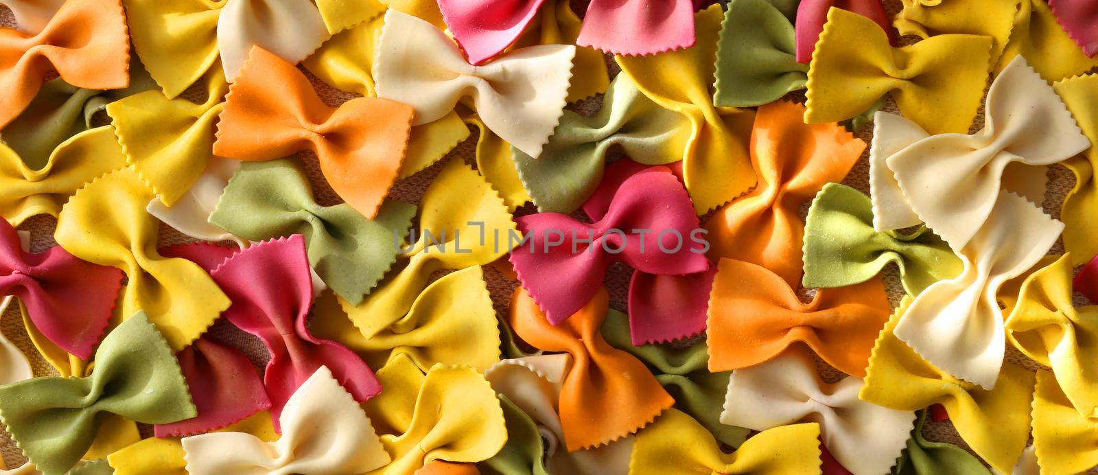 Italian pasta farfalle. Colourful green pasta background. Pasta recipes concept. Horizontal flat lay