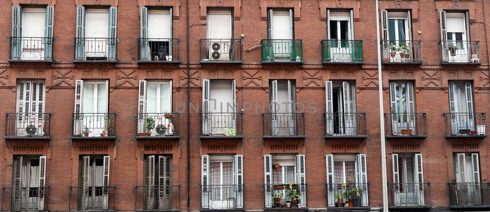 Red brick facade with wrought iron balconies in Madrid, Spain