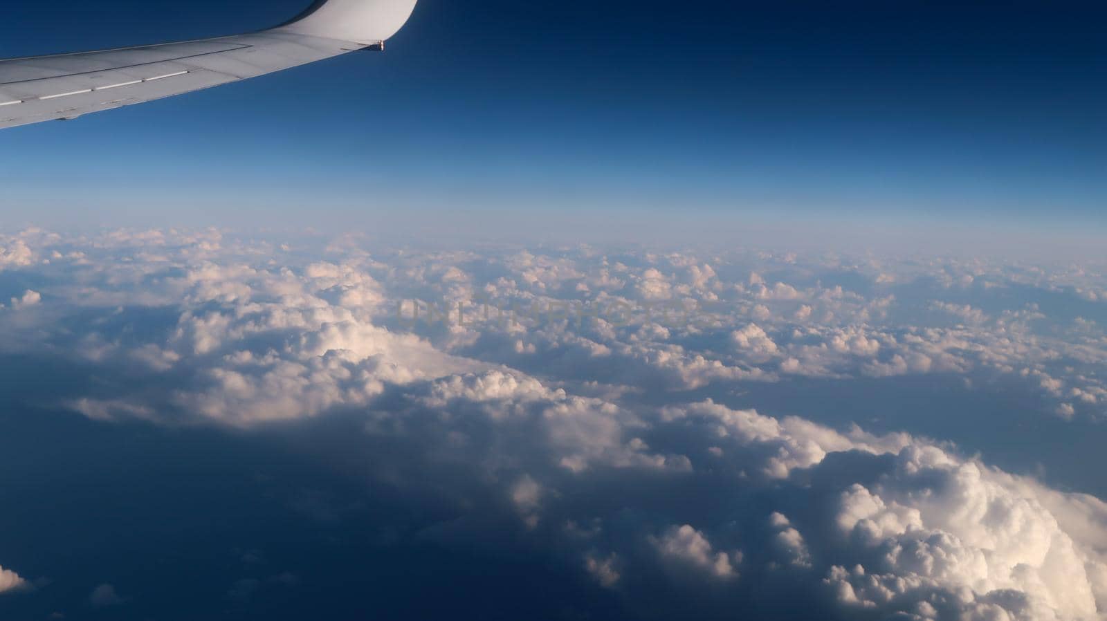 Cloudscape from airplane window. Clouds from above with airplane wing by codrinn