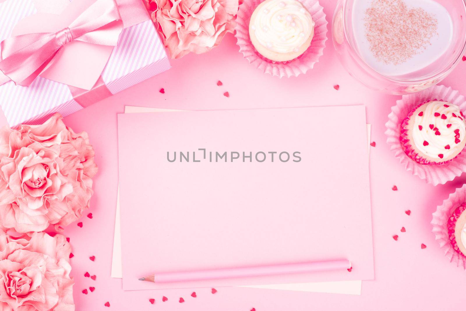 Valentines day pink background with blank love letter with copy space gift box rose flowers cupcakes pencil and drink