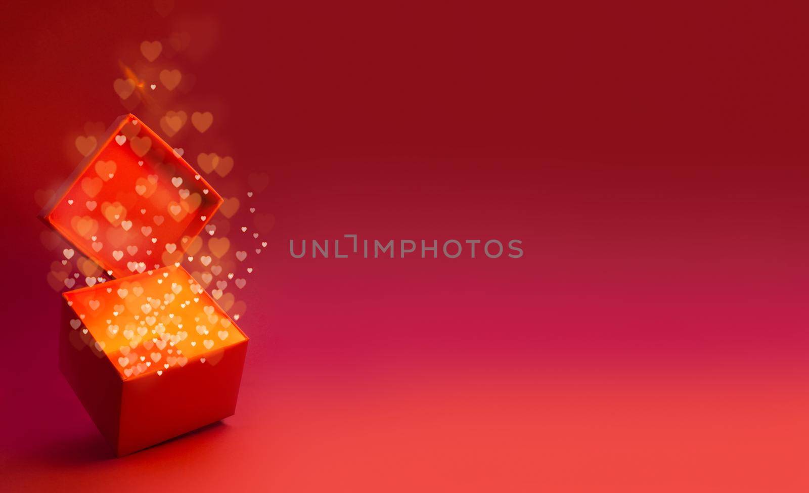 Magic box with love gift for Valentines day, pink red glowing with light from inside with bokeh hearts on glitter background with copy space for text