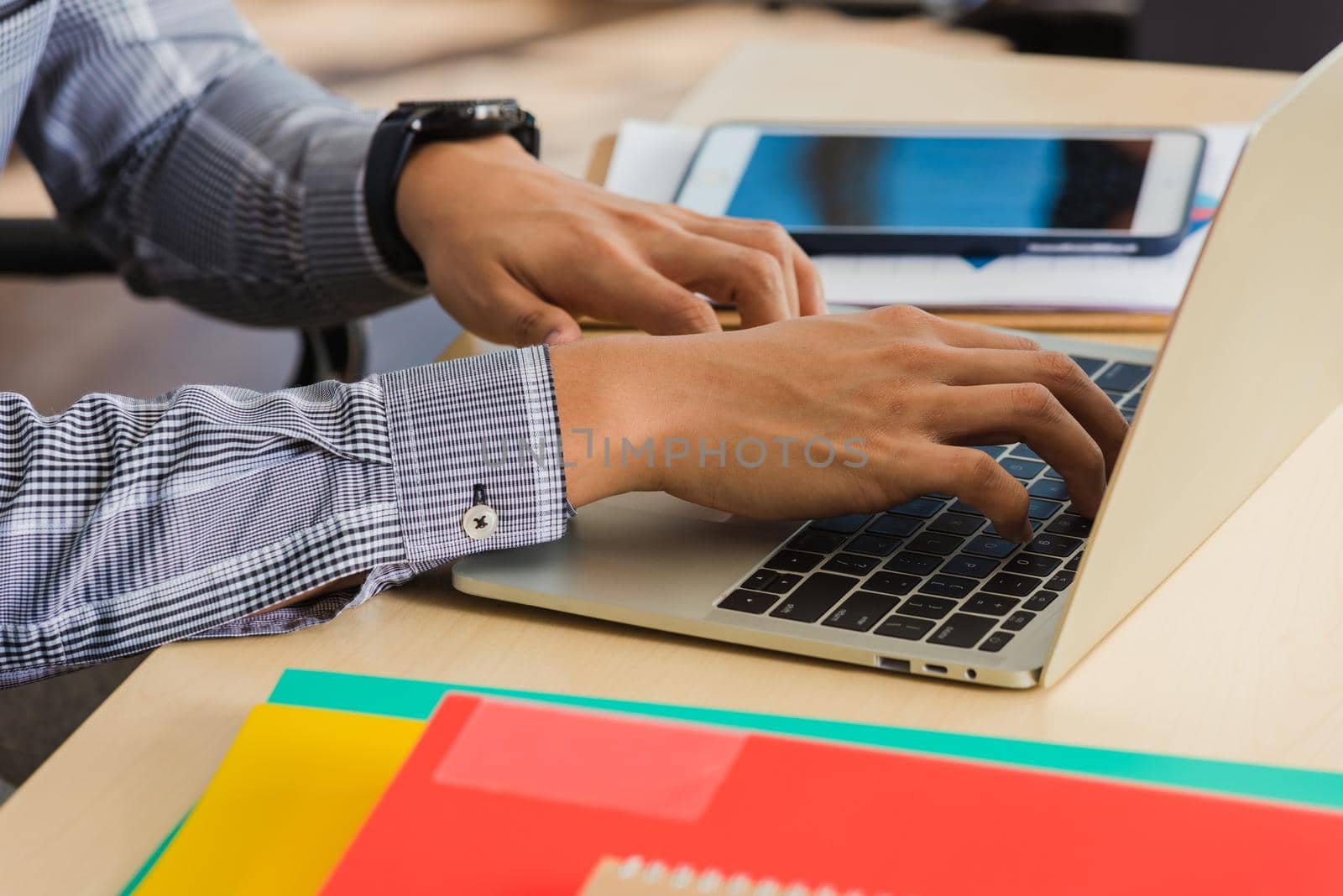 young handsome man using laptop at workplace by Sorapop