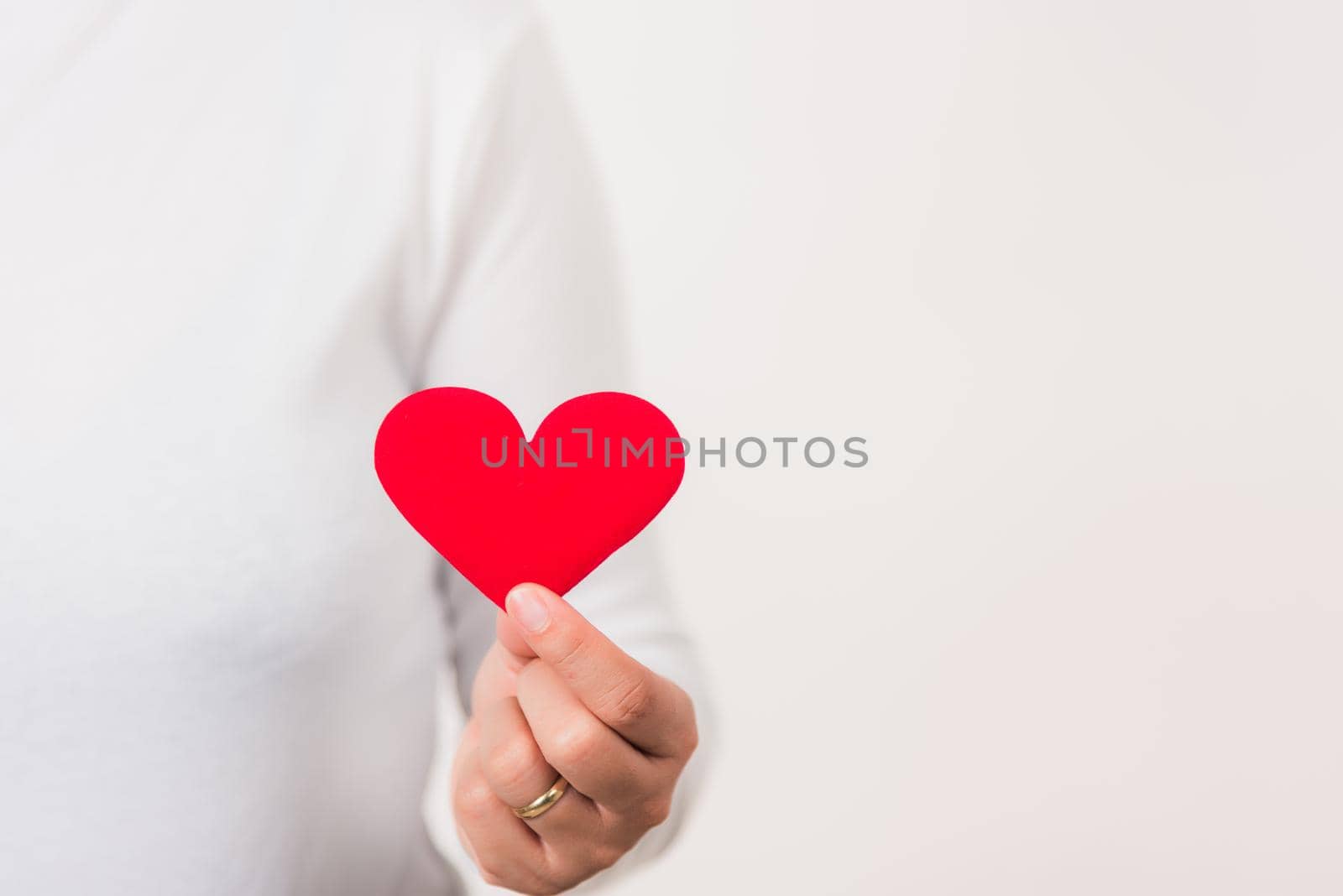 Woman beauty hands holding red heart for giving by Sorapop