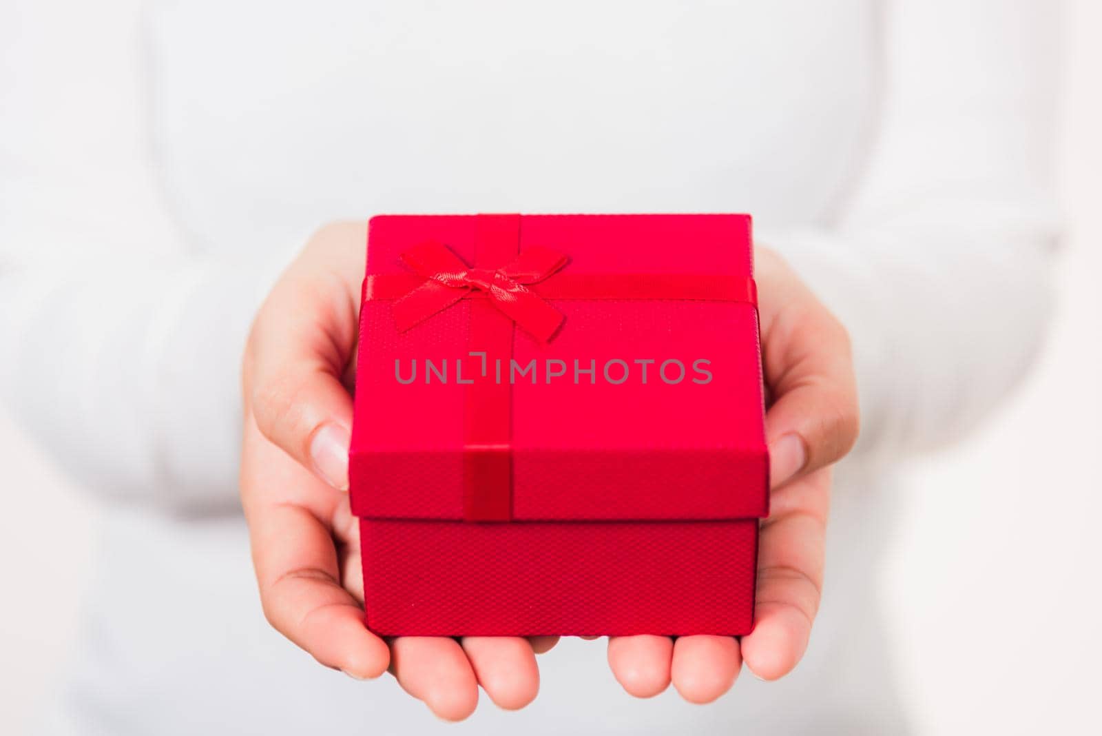 Valentine's Day. Woman beauty hands holding small gift package box present wrapped paper with ribbon isolated on white background, Birthday, New year, Christmas, holiday background concept