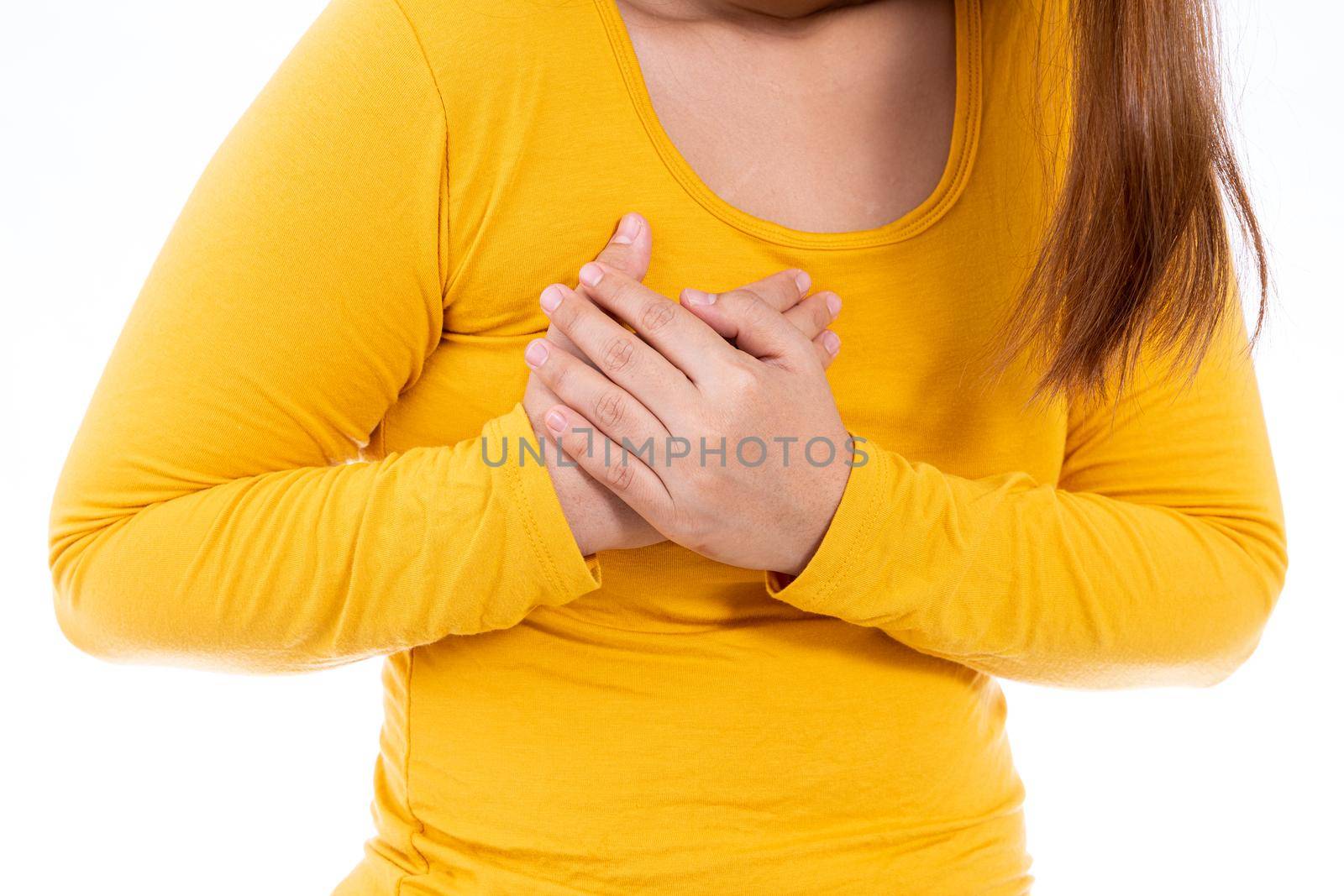 Woman touching her heart or chest isolated white background. Healthcare medical or daily life concept.