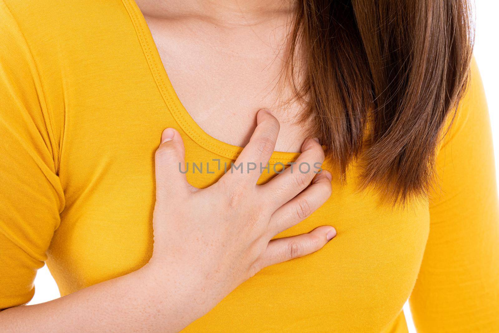 Woman touching her heart or chest isolated white background. Healthcare medical or daily life concept.