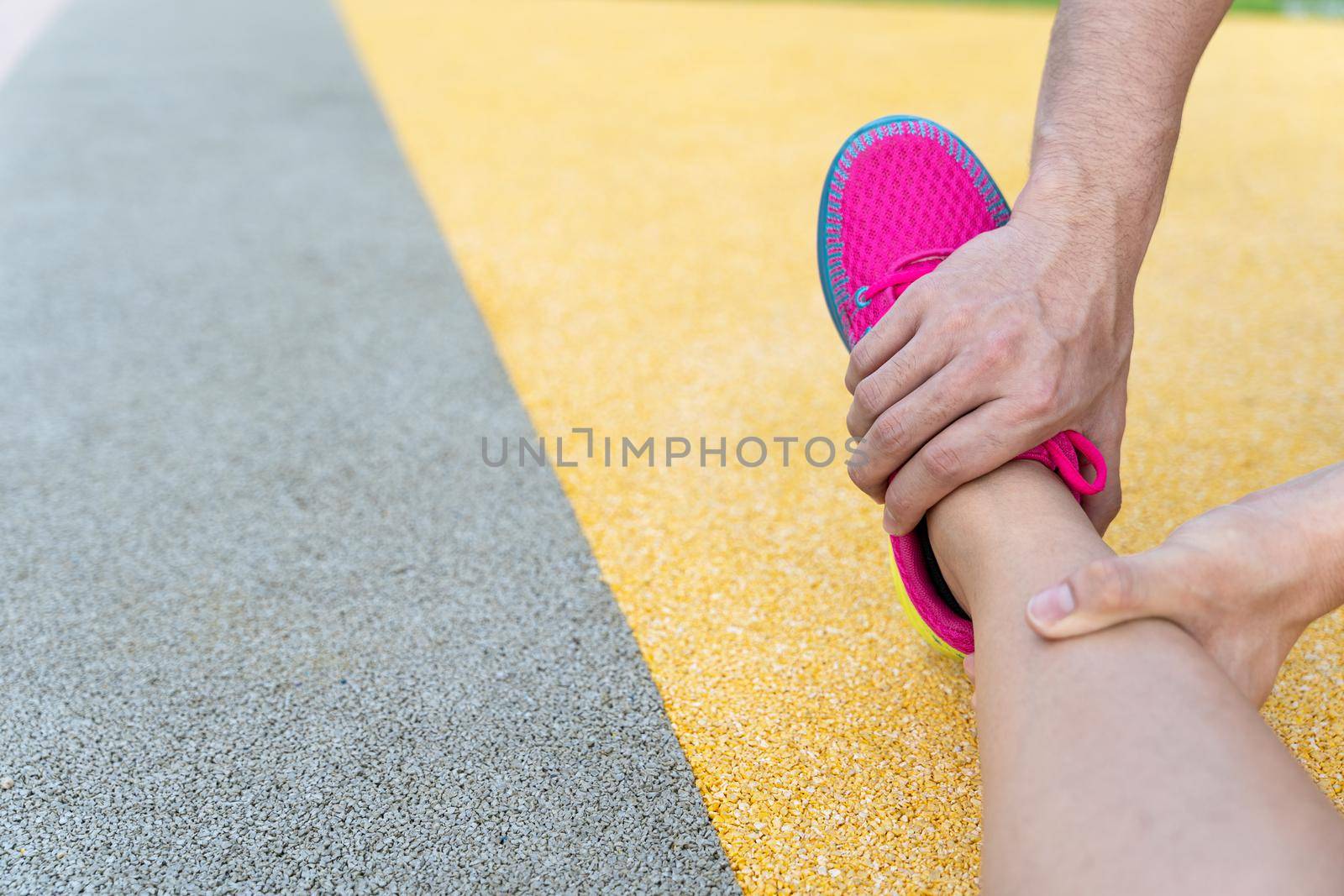 Male hand grab female leg to stretch after exercise injury. by mikesaran