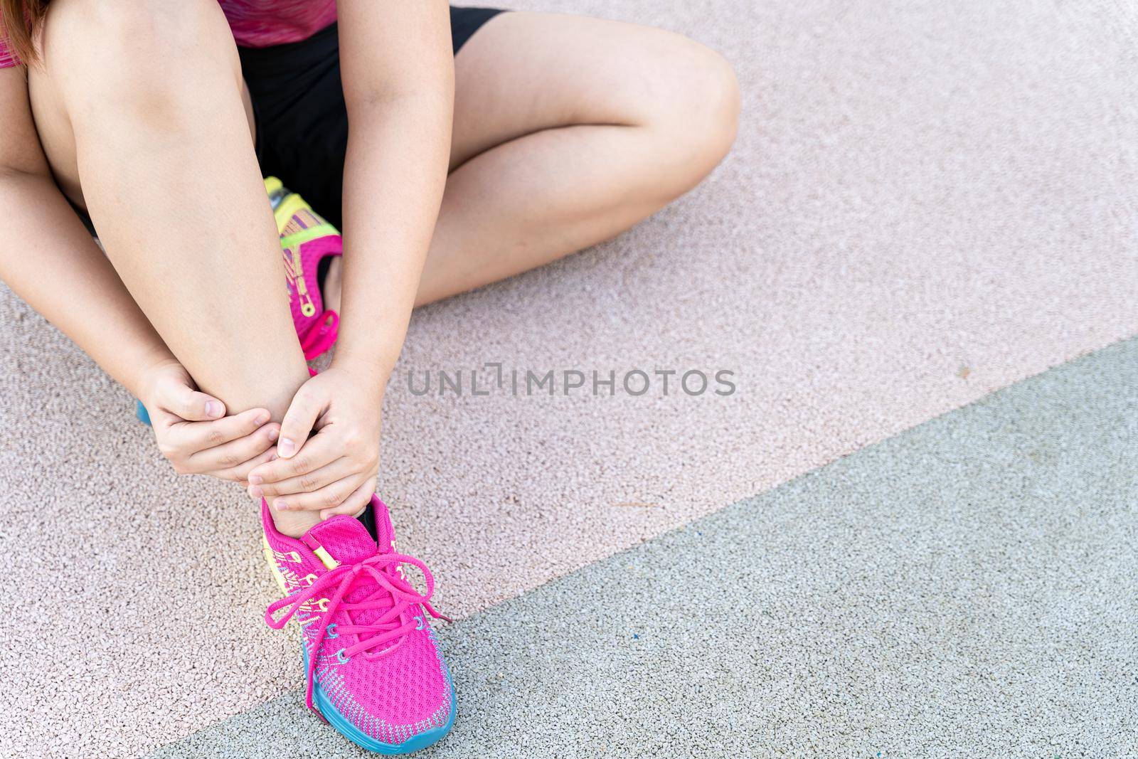 Female fatty runner athlete leg injury and pain. Hands grab painful leg while running in the park. by mikesaran