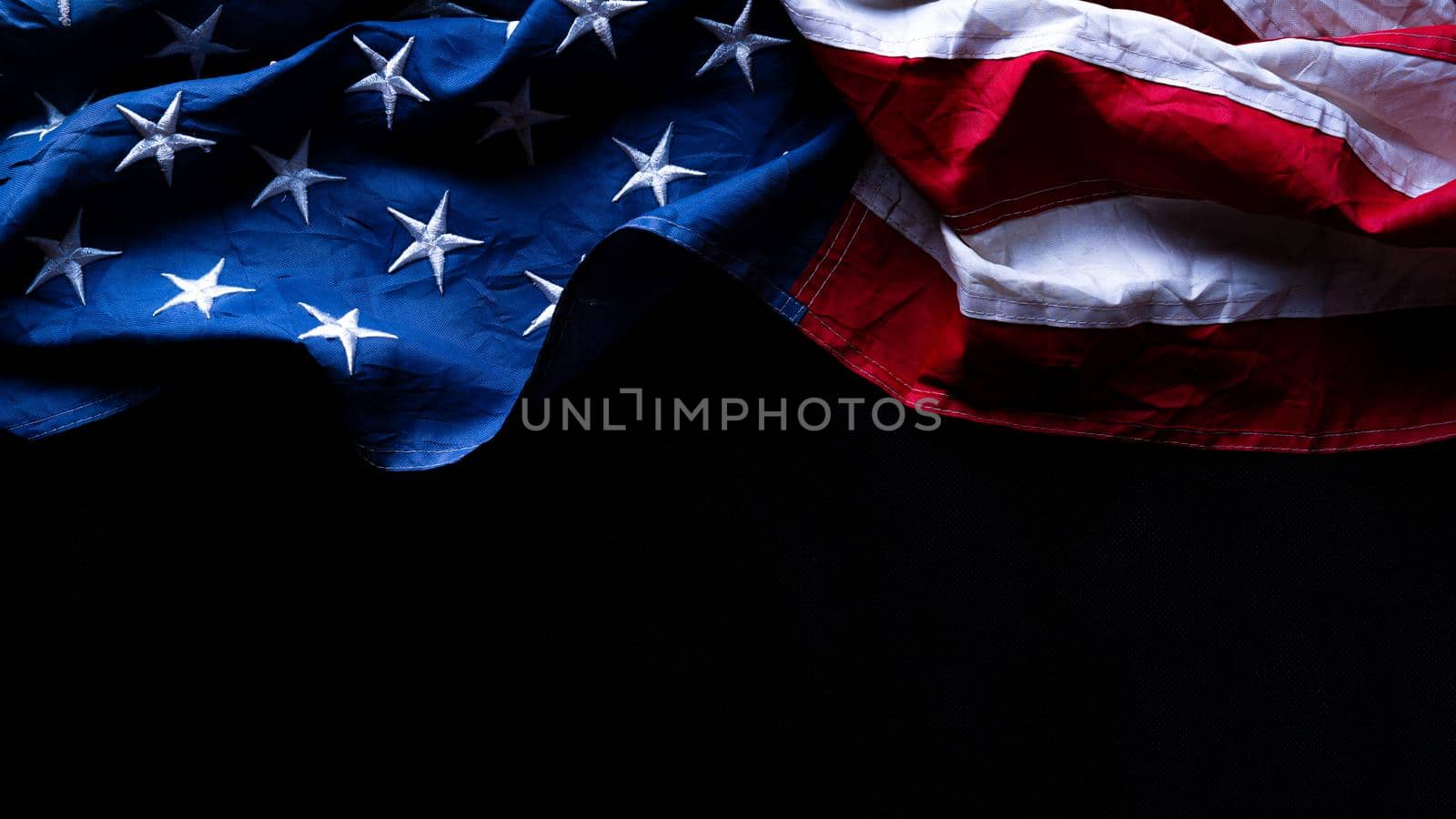 US American flag against black background. For Memorial, Presidents, Veterans, Labor, Independence or 4th of July celebration day. Top view, copy space for text.