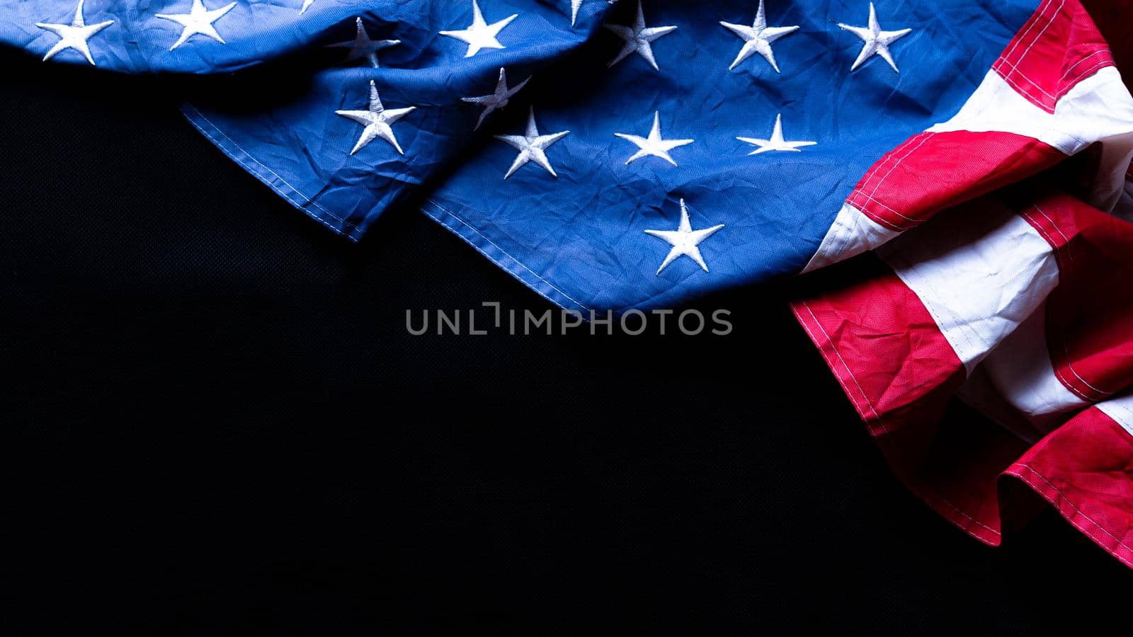 US American flag against black background. For Memorial, Presidents, Veterans, Labor, Independence or 4th of July celebration day. Top view, copy space for text.