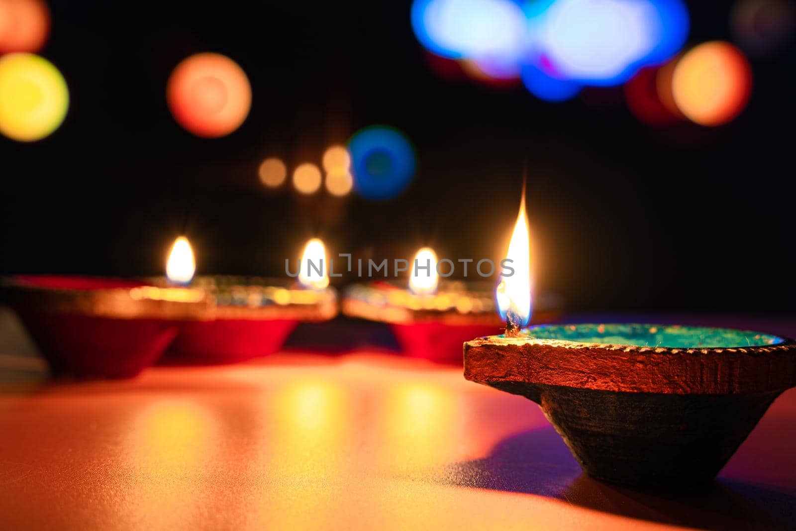 Indian festival Diwali, Diya oil lamps lit on colorful rangoli. Hindu traditional. Happy Deepavali. Copy space for text. by mikesaran